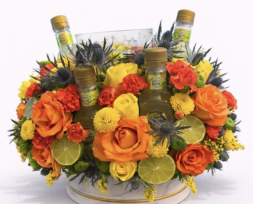 Orange and yellow floral arrangement with three mini liquor bottles and lime slices