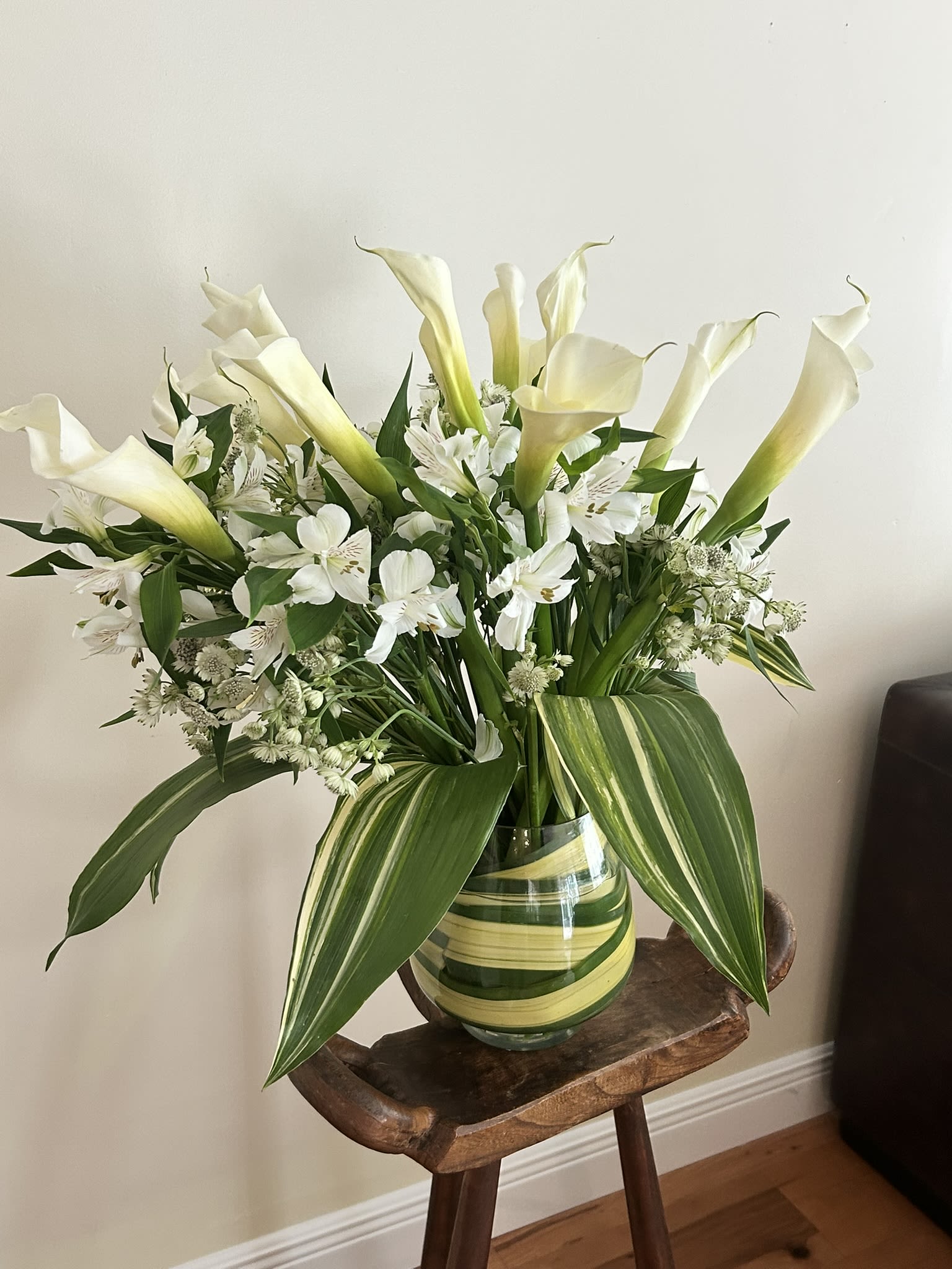 Calli Lily Mix  - 12 Dozen long stem Calli Lilies with seasonal accents (shown with Astrantia and Alstroemeria) and greens, and wrapped vase. Please CALL for availability.