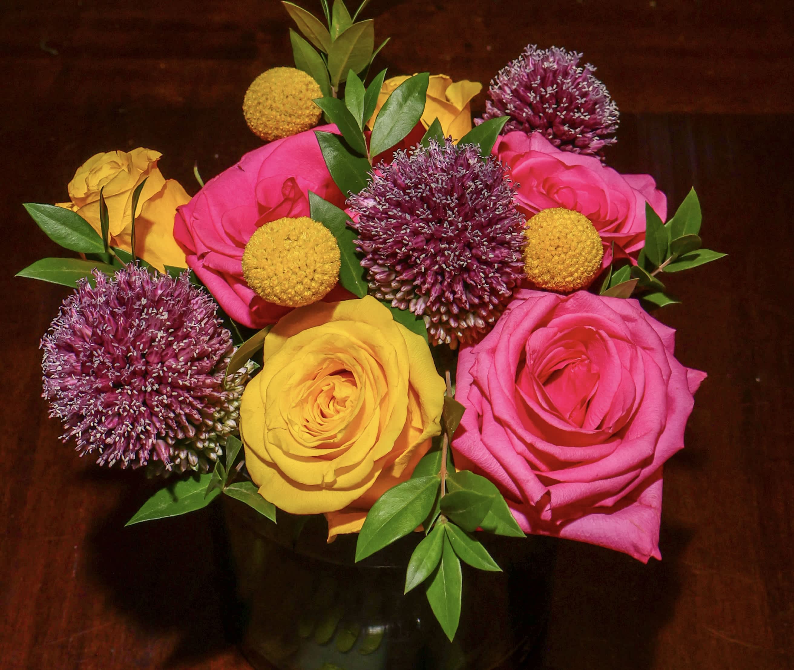 Bouquet of pink and yellow roses with purple allium blooms