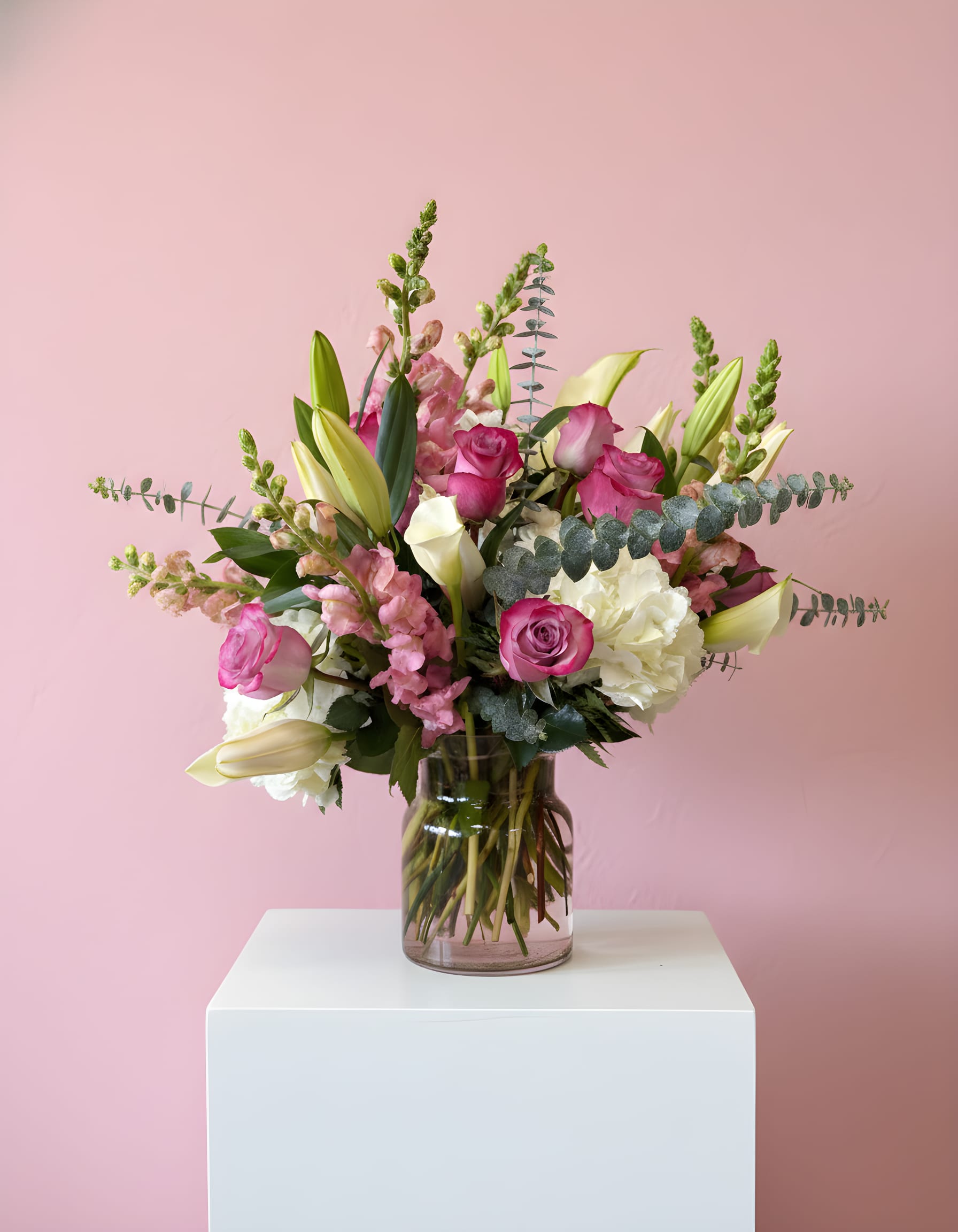 Pink and white floral arrangement in a glass vase