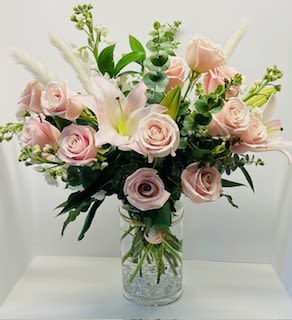 Pink roses and white lilies in a clear glass vase