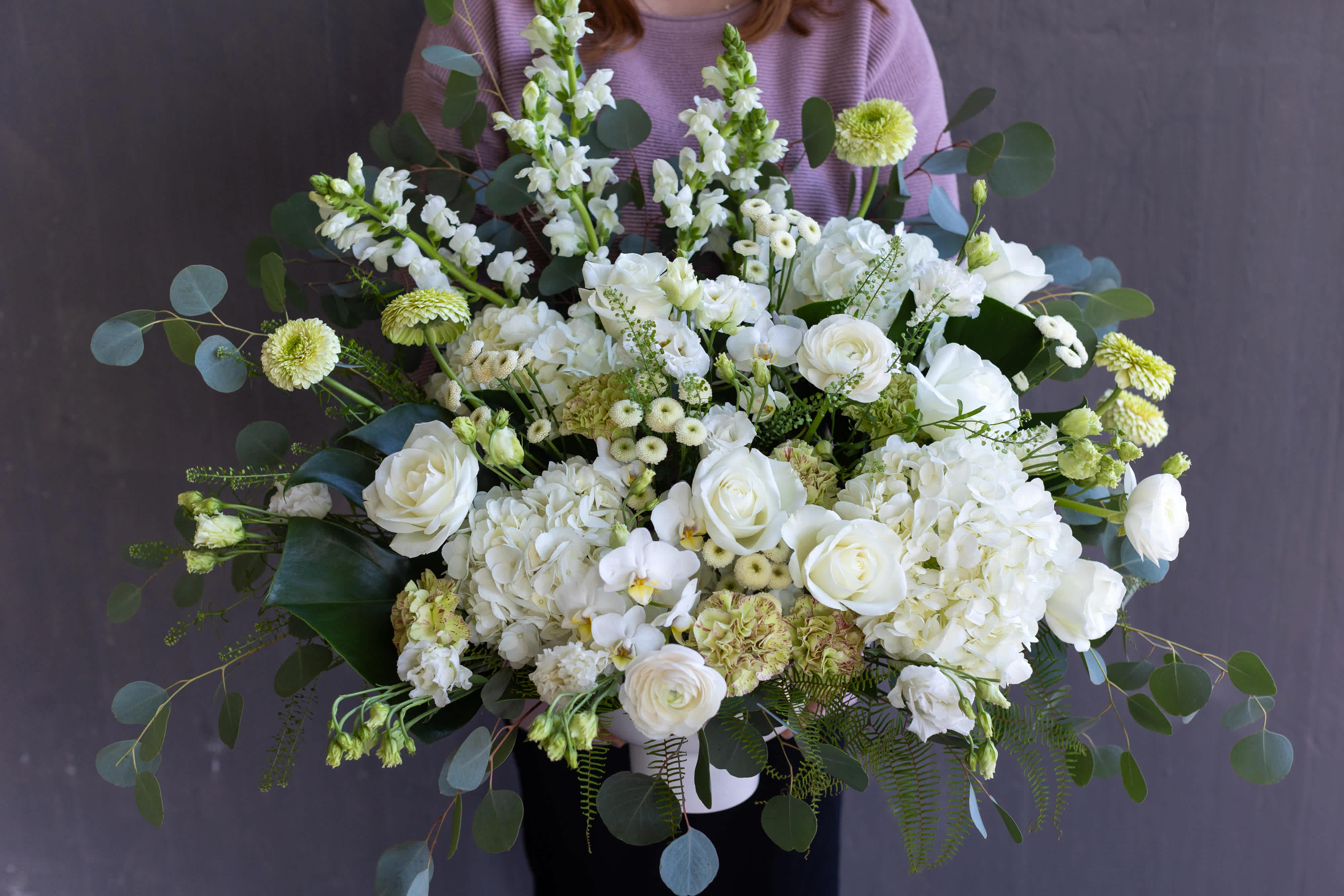 Large white floral arrangement with roses and hydrangeas