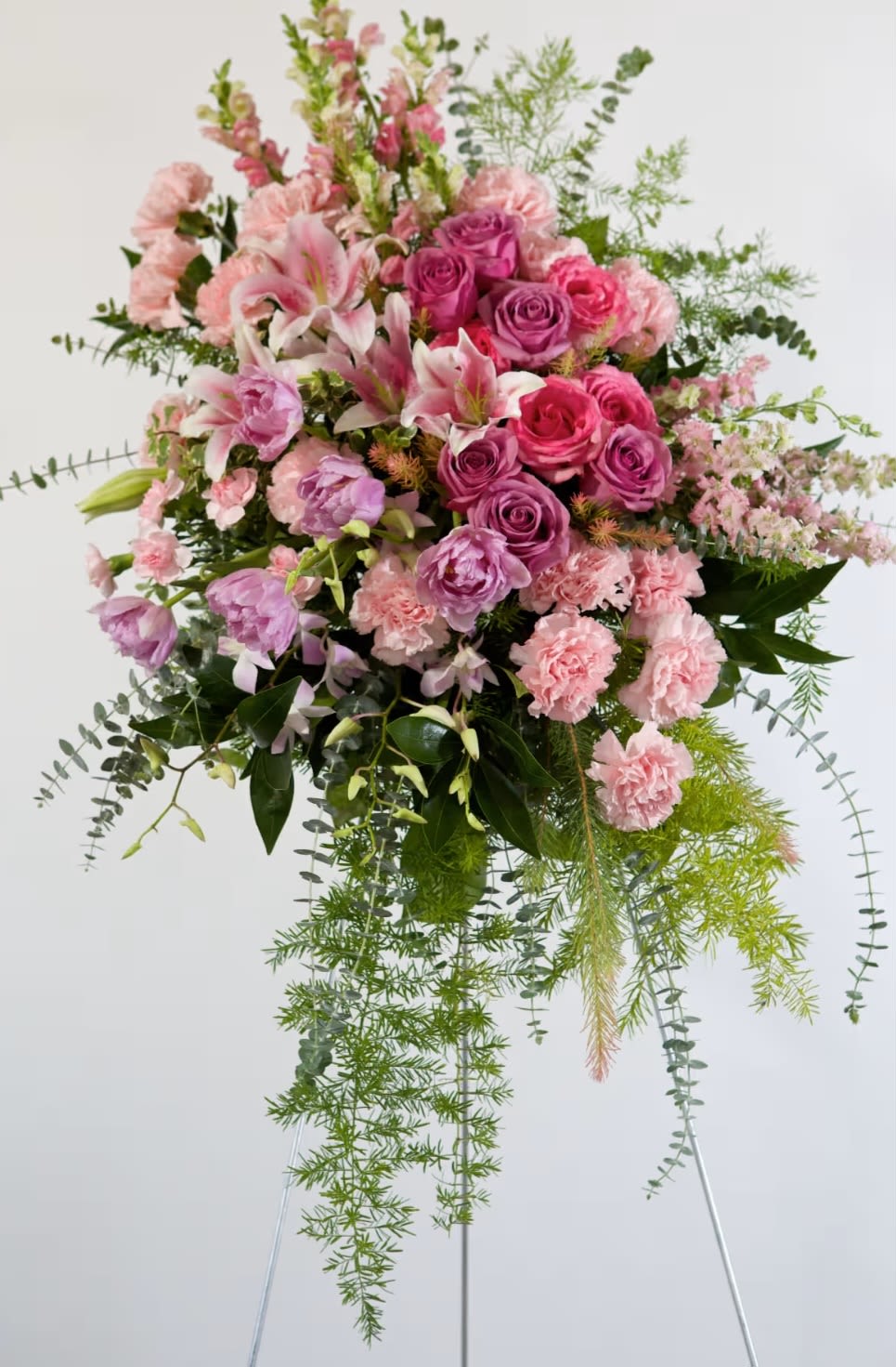Large pink and lavender floral arrangement with cascading greenery