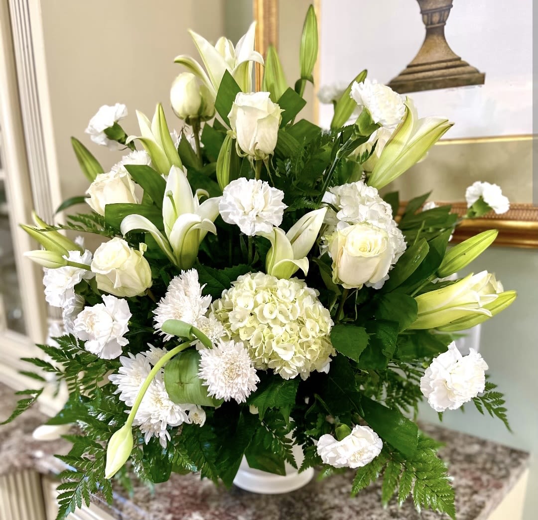 White floral arrangement with lilies, roses, hydrangea, and carnations