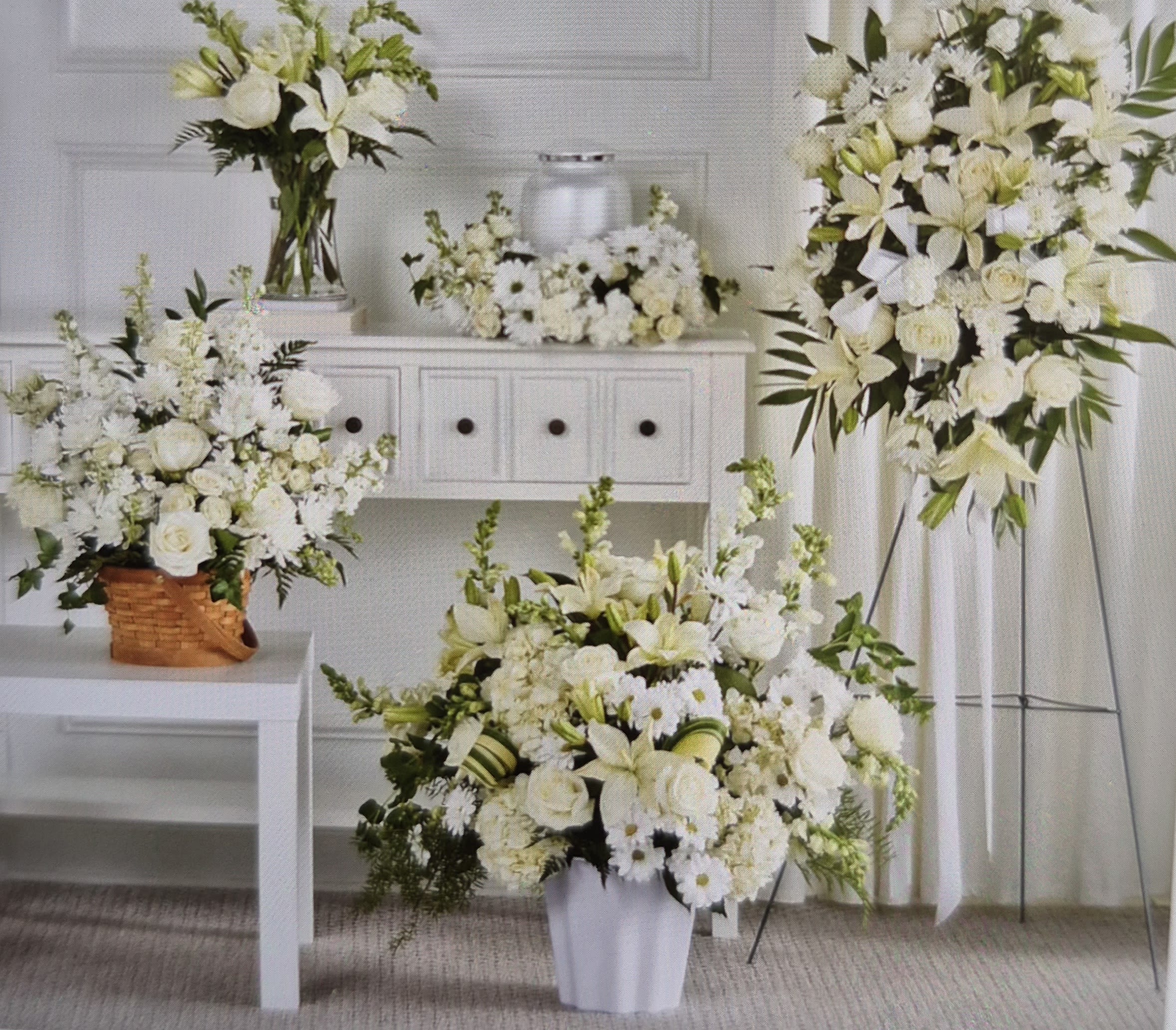 White floral arrangements in vases and a standing spray