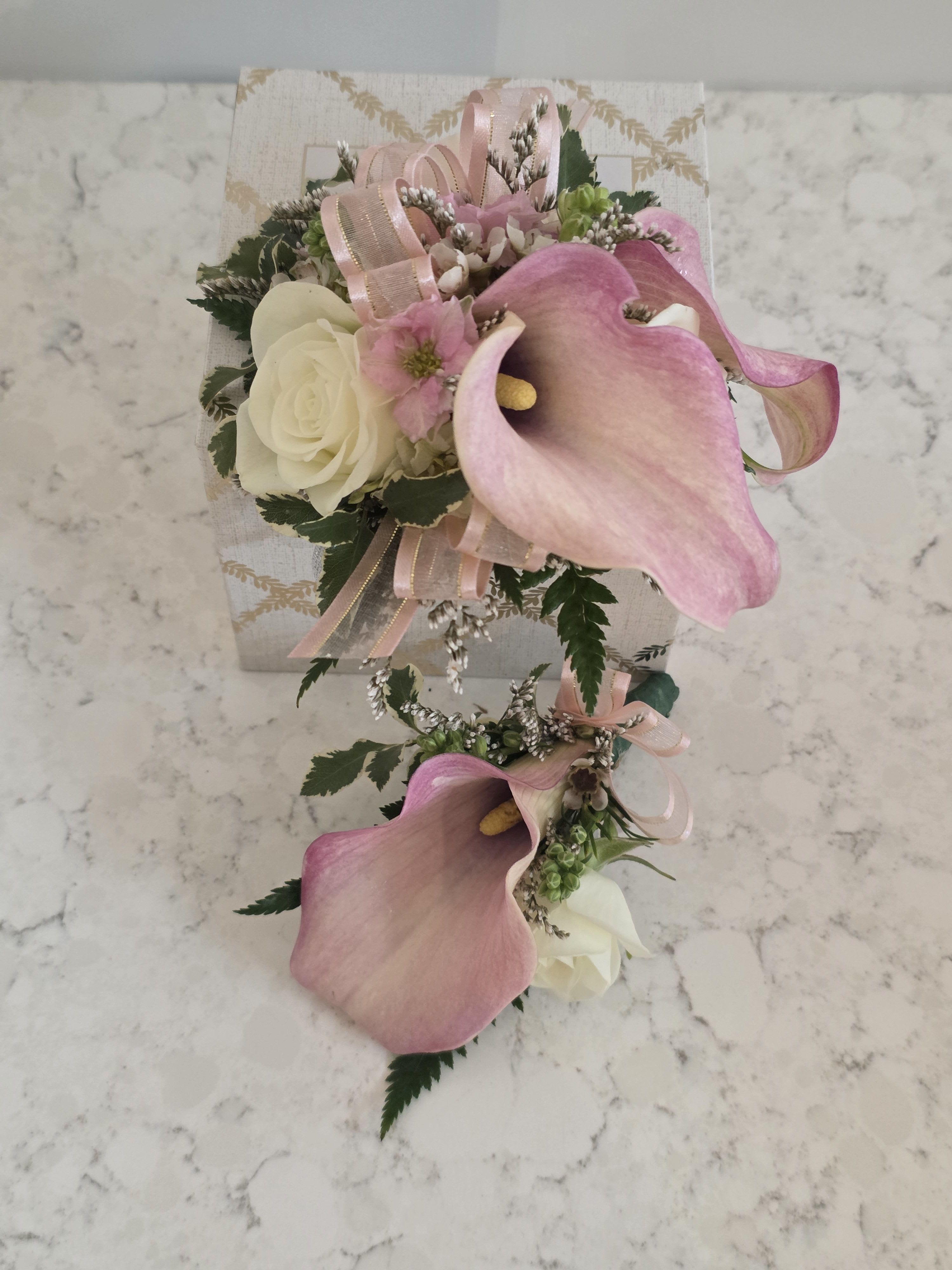 Prom Corsage &amp; Boutonniere Combo - Calla Lilies  - A delicate pairing of mini calla lilies, and roses makes this prom corsage and boutonniere combo the perfect finishing touch for formal nights and graduation dances. Styled in white, blush pink, and fresh green, this prom corsage &amp; boutonniere set is designed for prom or a wedding-ready look-an elegant choice when you want her to feel cherished and him to look polished at the same time.  