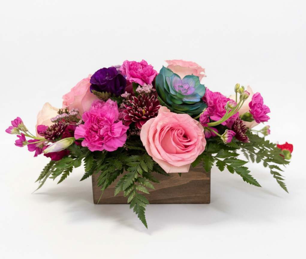 Pink and purple floral arrangement in a wooden box