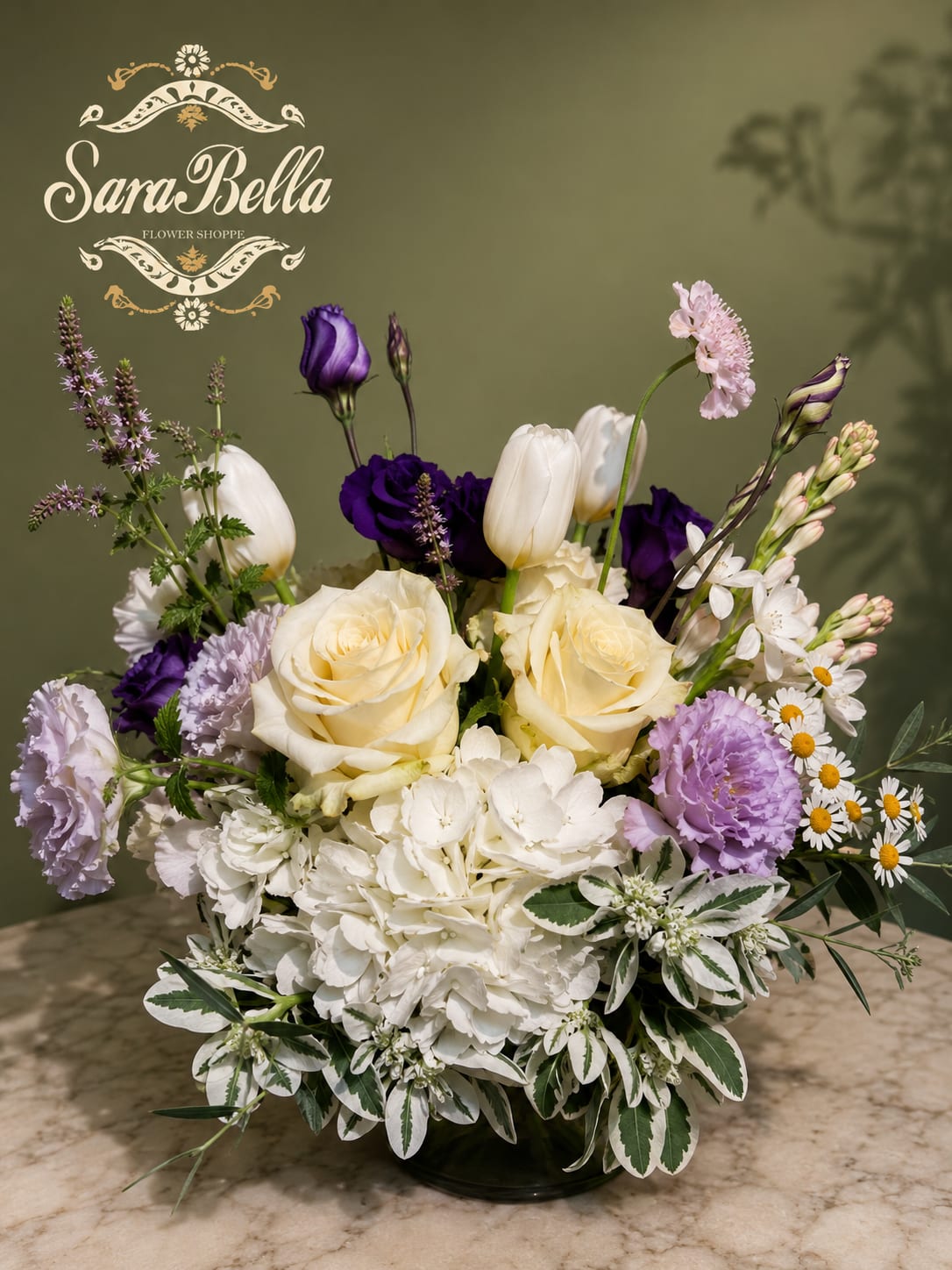 Bouquet of cream roses, white hydrangea, and purple blooms in a low vase