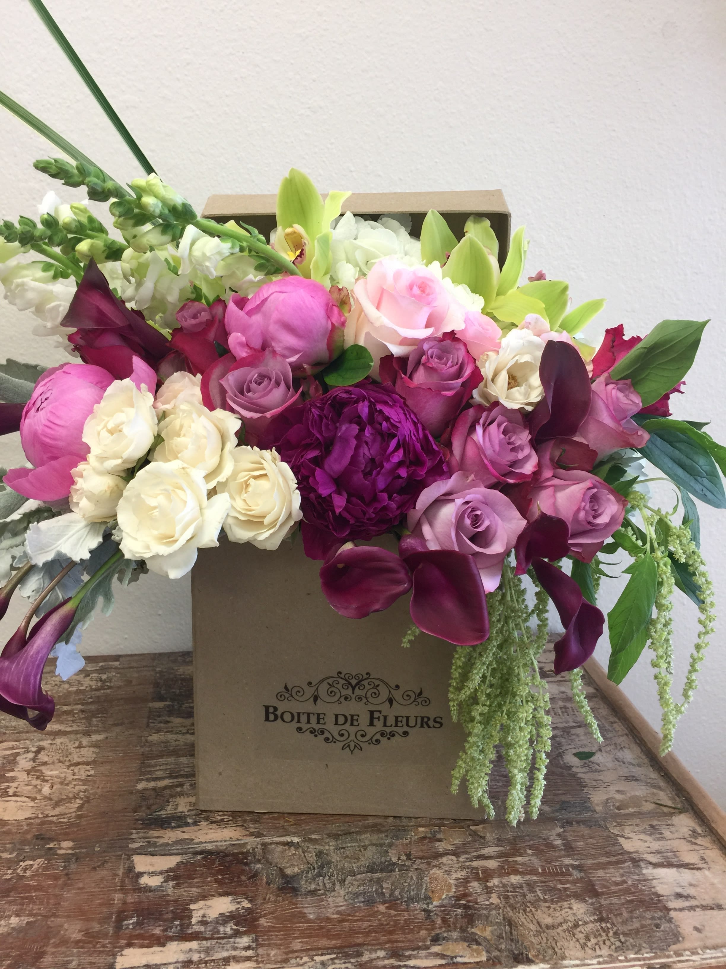 Mixed pink, white, and purple flowers arranged in a box