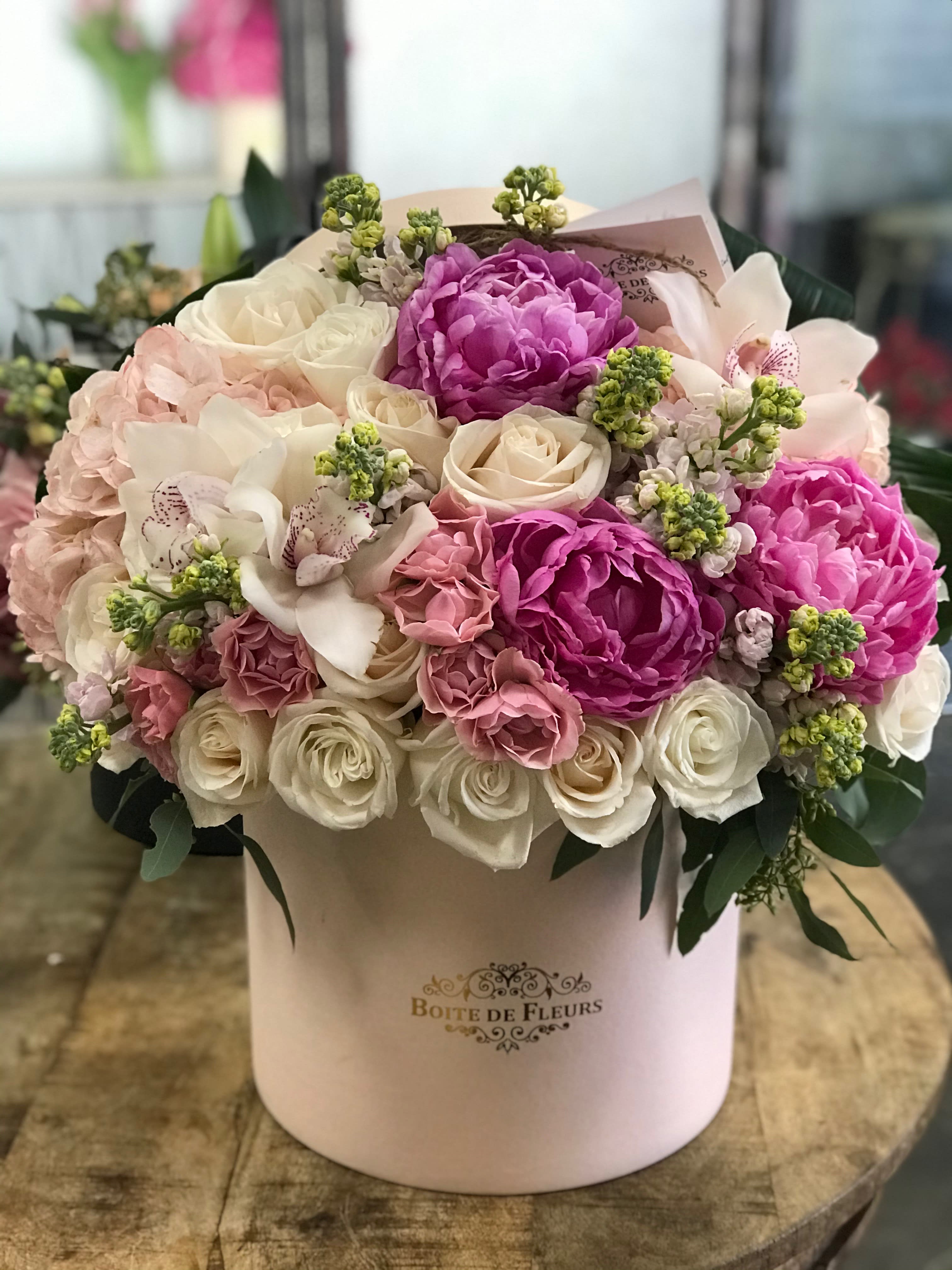 Pink and white bouquet in a round hatbox