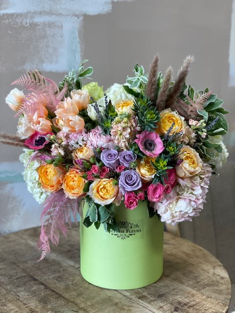 Mixed pastel bouquet in a green hatbox