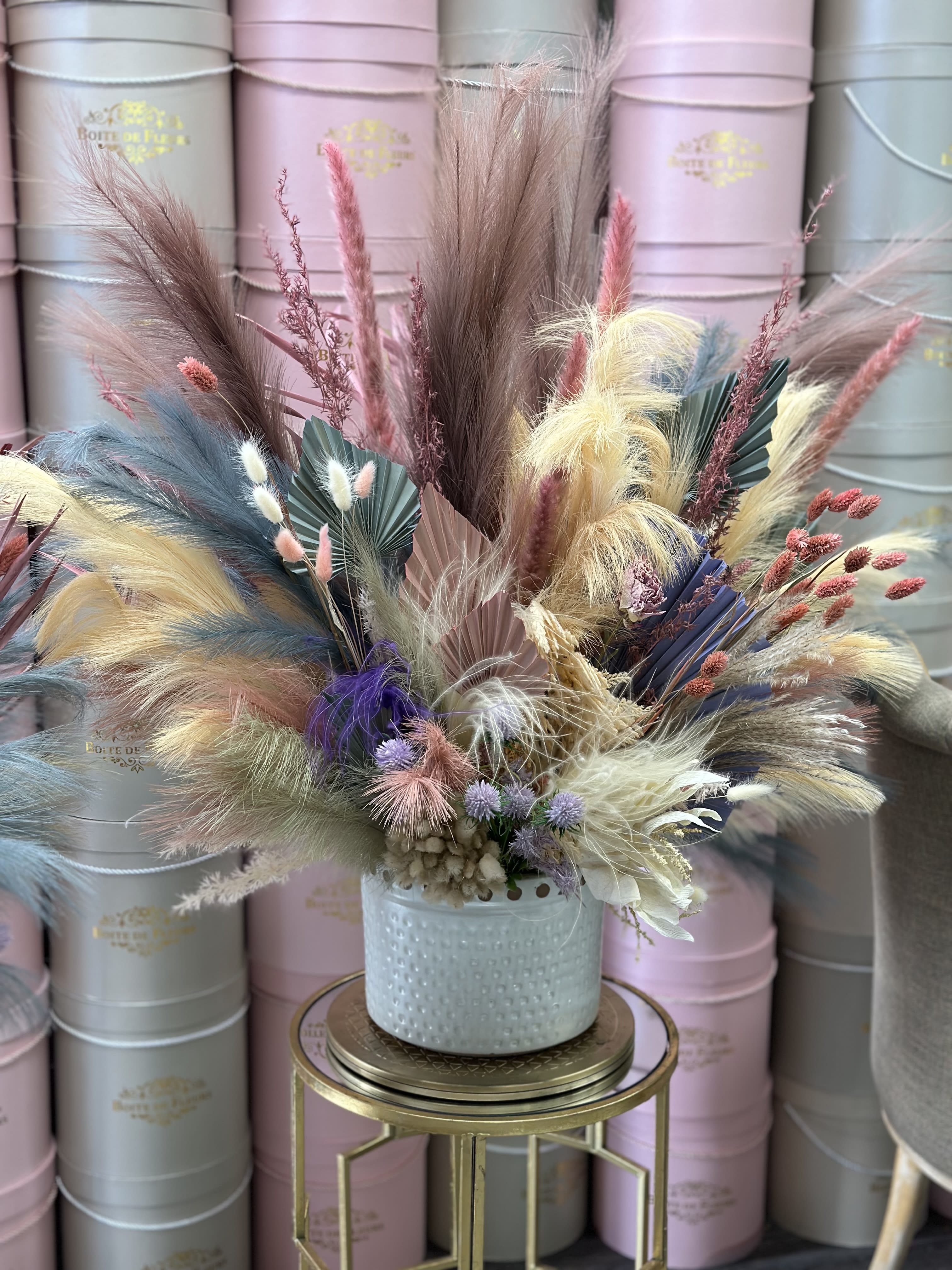 Pastel dried floral arrangement in a light blue vase