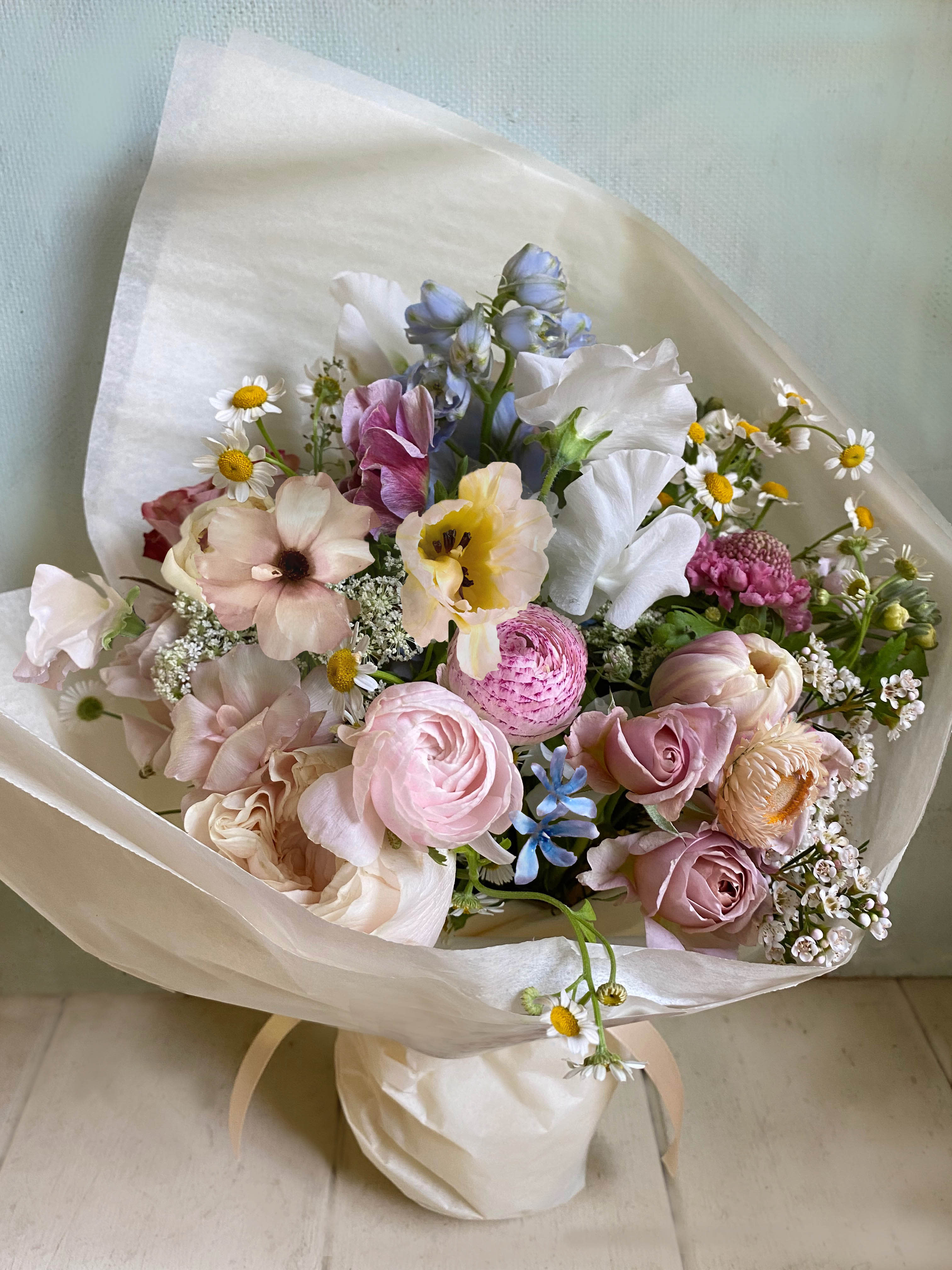 Nora Natural Bouquet - Lovely, light and beautiful hand tied bouquet (comes without a vase, a vase can be added at checkout). Created of pretty seasonal flowers in a light palette. Sweetpeas, stock, chamomille, lilacs, peonies, ranunculues - or other beautiful stems in season. As farm fresh and natural as possible, wrapped in beautiful silk paper with ribbon. We offer a personal hand delivery by our own delivery staff and guarantee the flowers will look perfect, when they arrive.