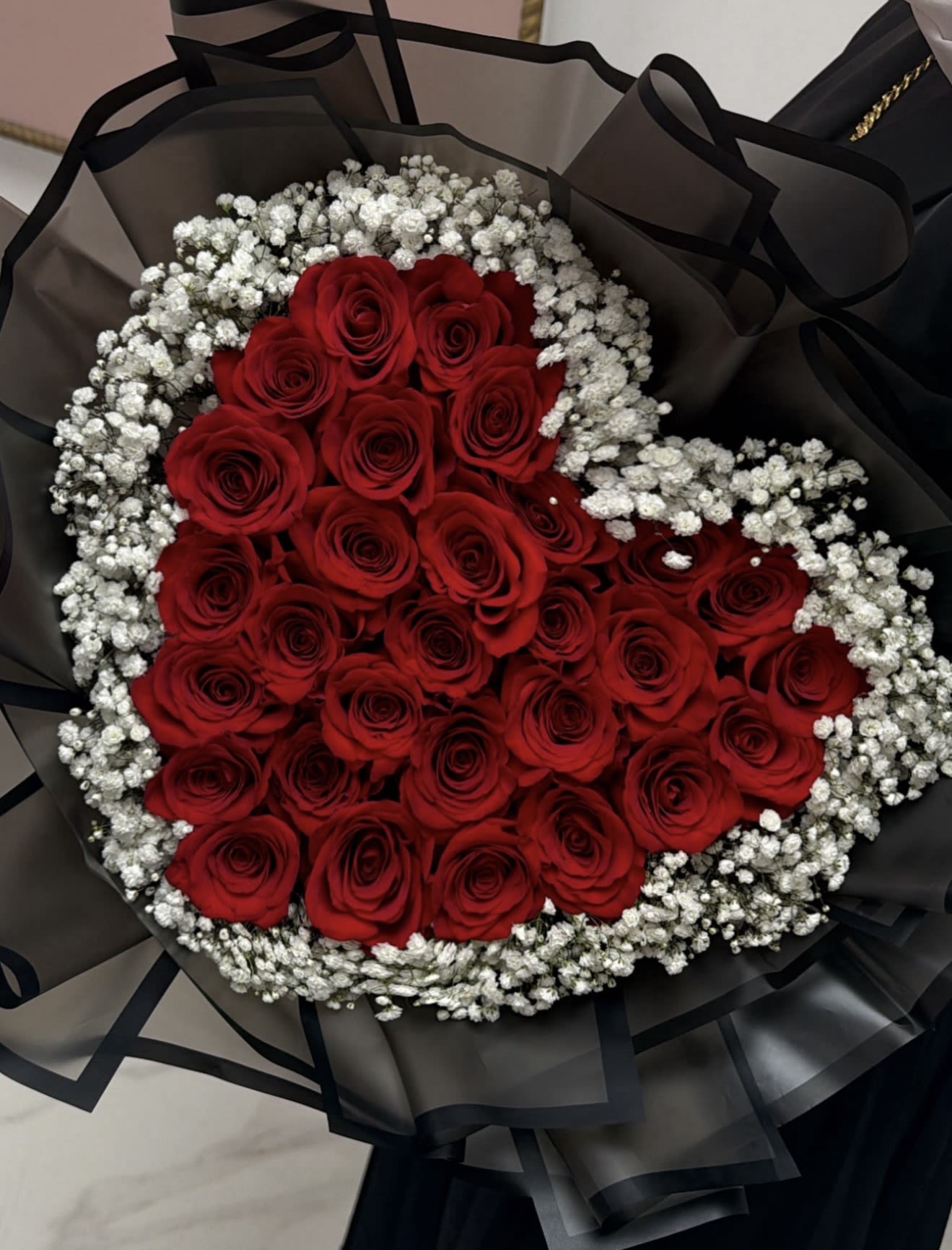 Heart-shaped bouquet of red roses with white baby's breath