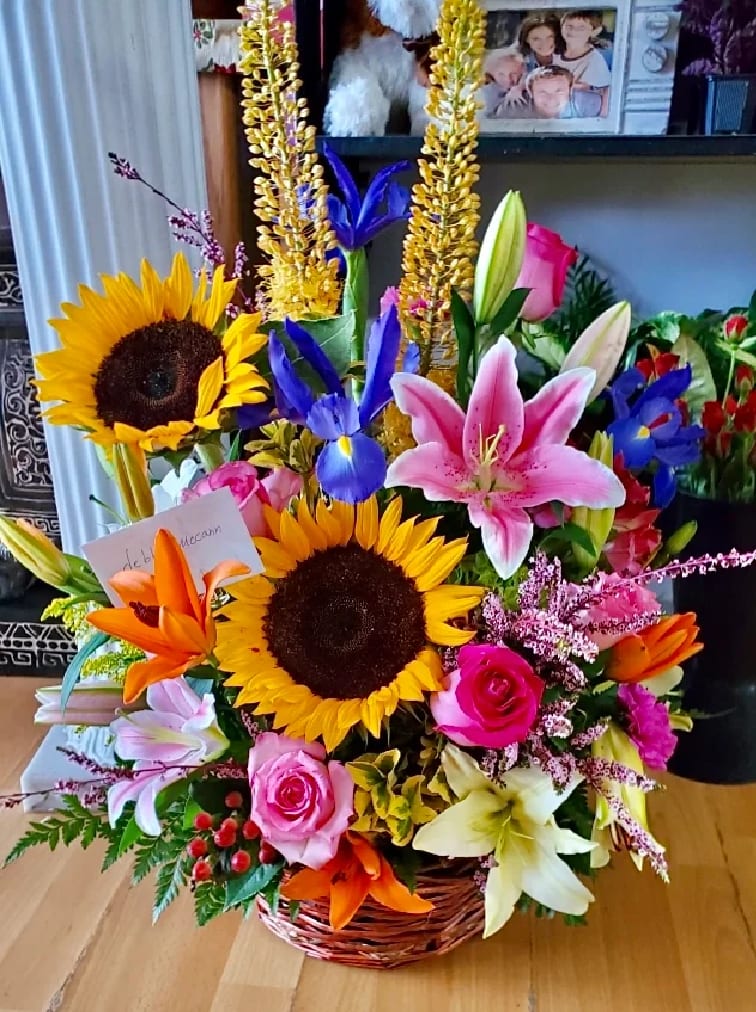 Basket arrangement with sunflowers, lilies, roses, and irises
