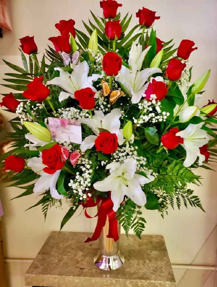 Red roses and white lilies in a tall glass vase