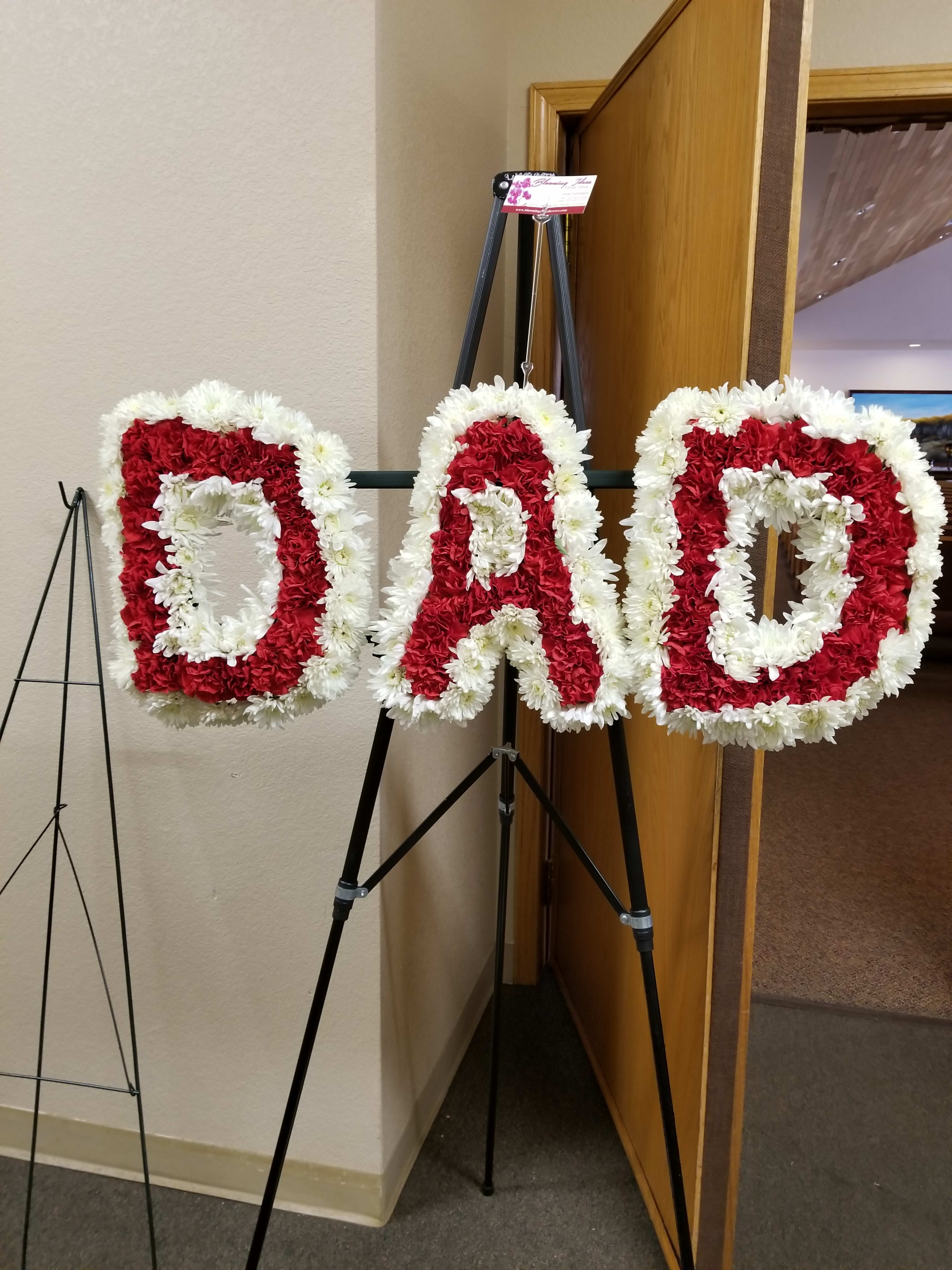 Floral standing letters spelling DAD in red and white flowers
