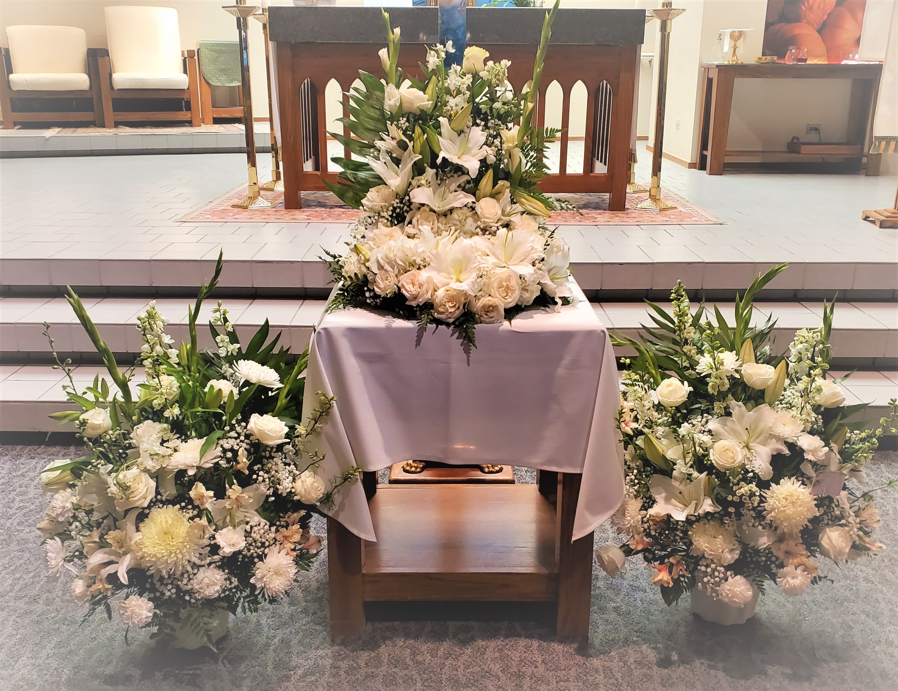 White floral arrangements around a church altar