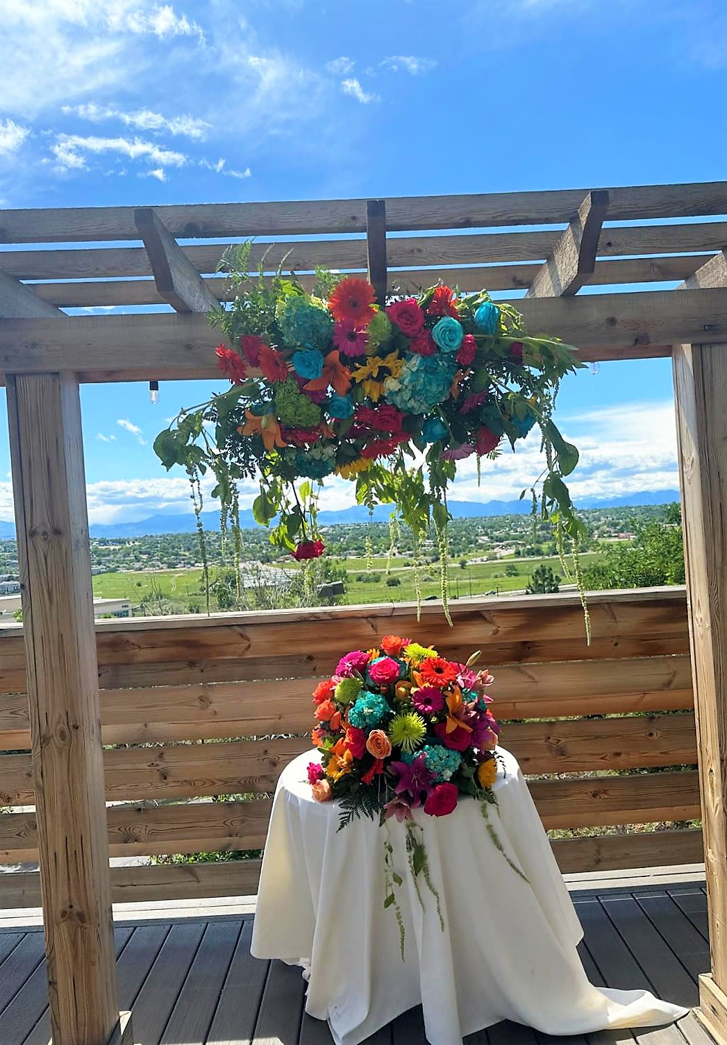 Bright multicolored floral arrangements on a table and hanging overhead