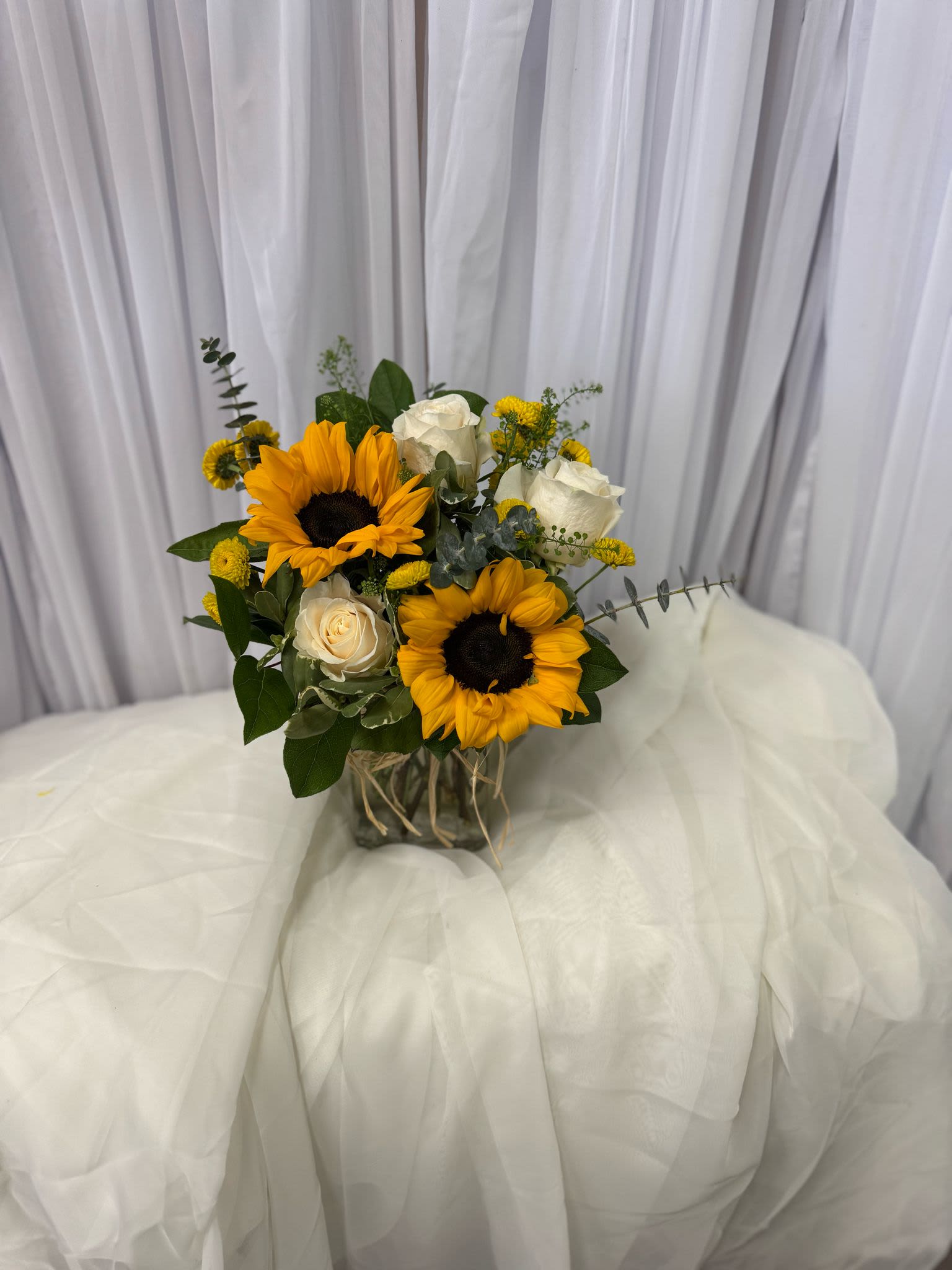 Bouquet of sunflowers and white roses in a glass vase