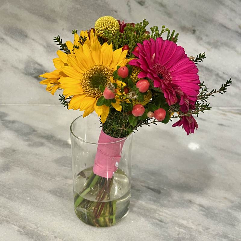 Bouquet of yellow and pink gerbera daisies in a clear glass vase