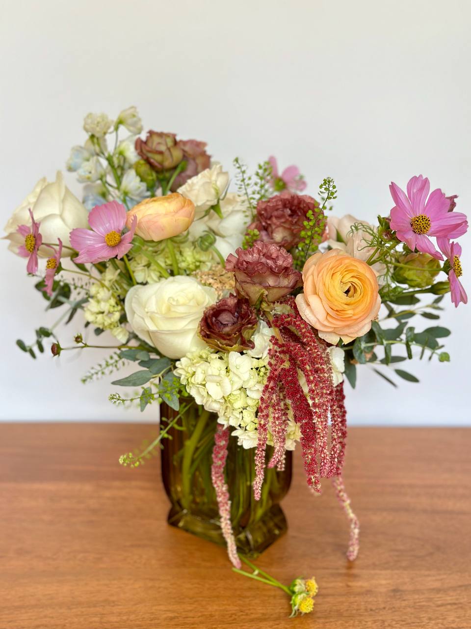 Mixed pastel bouquet in an amber glass vase
