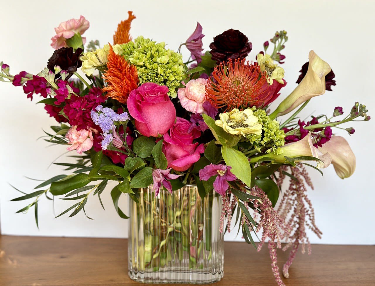 Mixed bouquet in a clear glass vase with pink, orange, and cream blooms