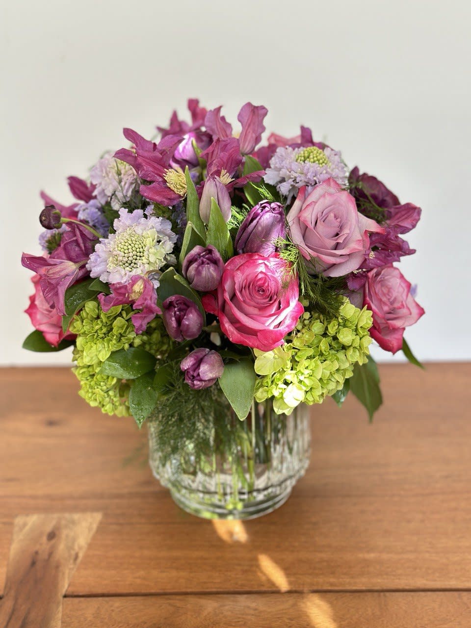 Pink and purple flower arrangement in a clear glass vase