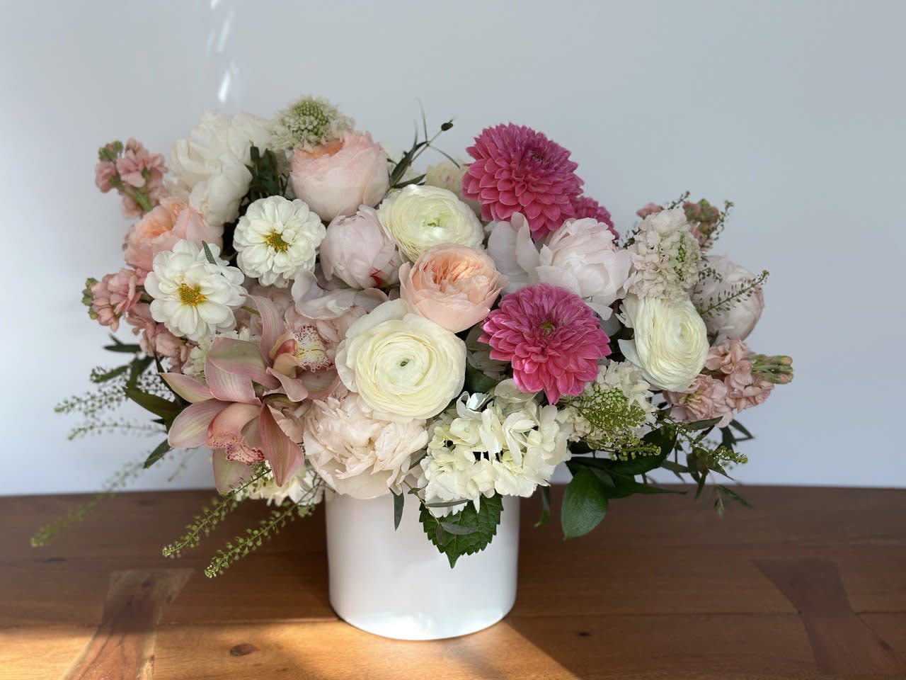 Mixed pastel flower arrangement in a white vase