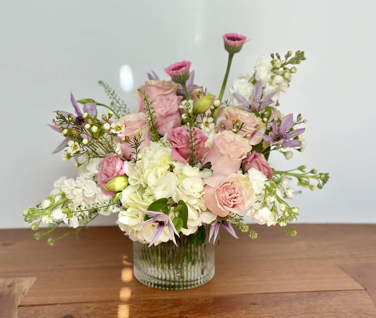 Pink and white floral arrangement in a clear glass vase