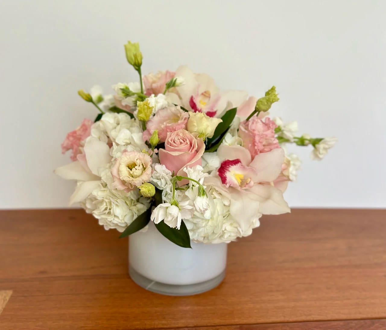 Pink and white floral arrangement in a white vase