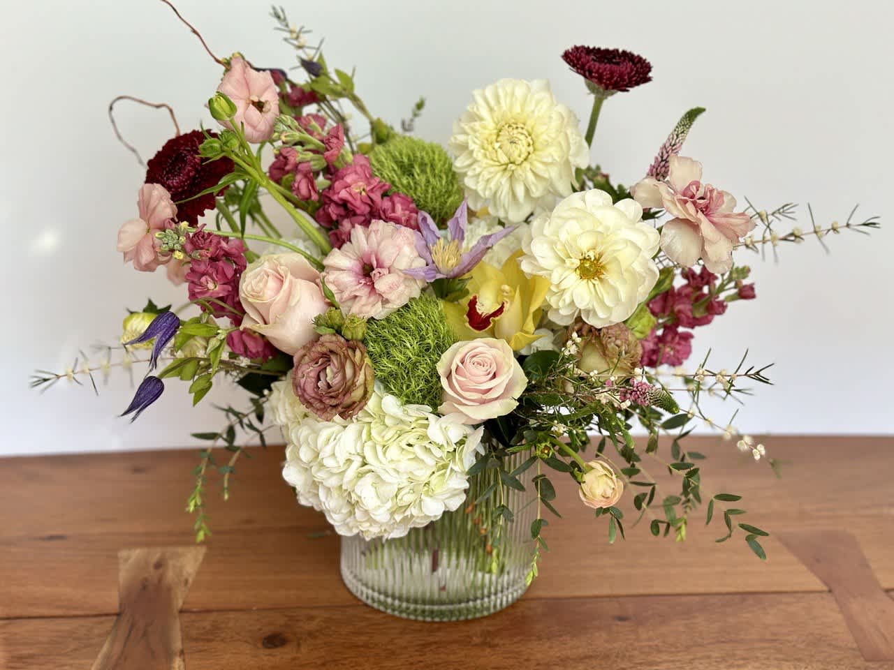 Mixed bouquet of pink, white, and yellow flowers in a glass vase