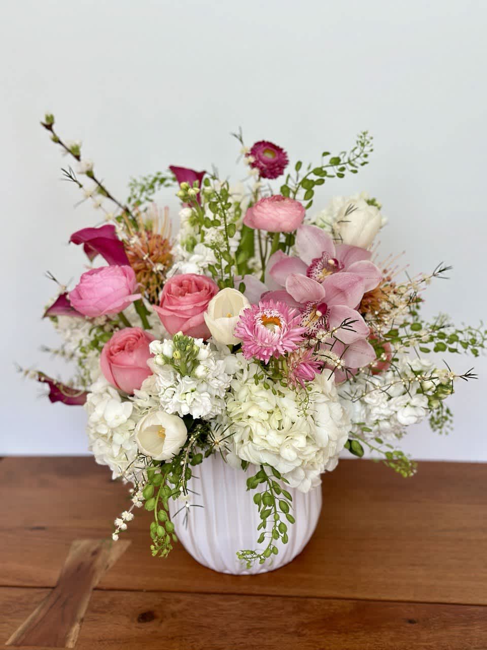 Pink and white mixed flower arrangement in a white vase