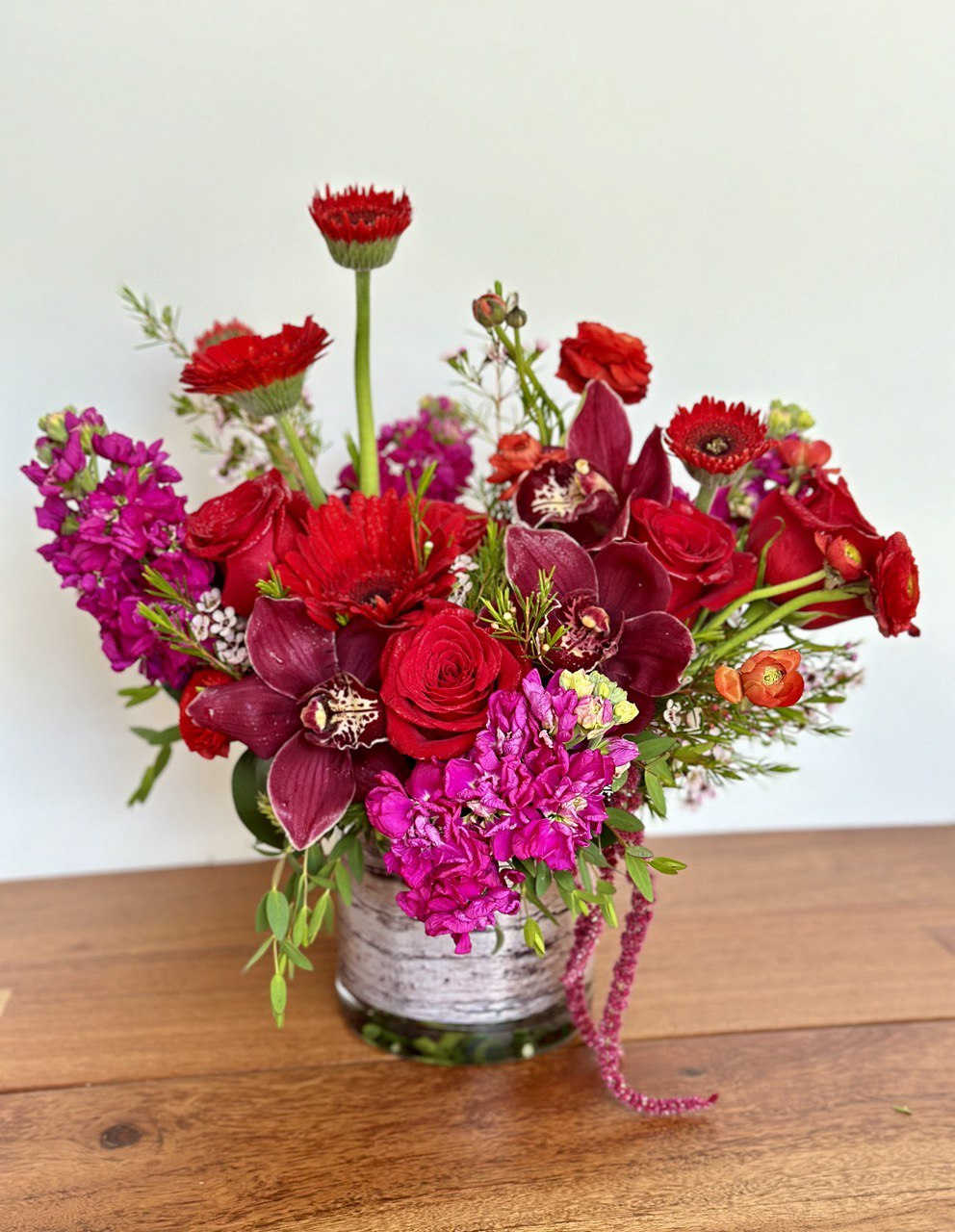 Red and magenta mixed bouquet in a glass vase