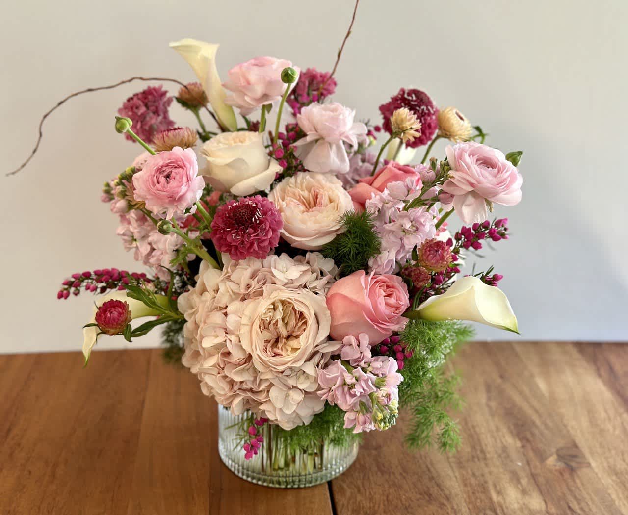 Pink and cream floral arrangement in a glass vase
