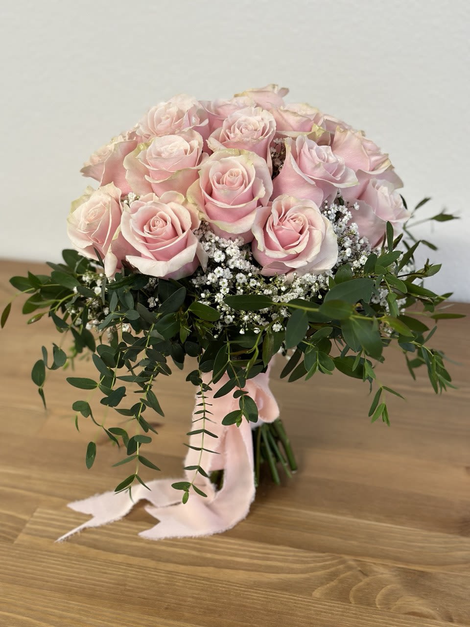 Bouquet of pale pink roses with white filler flowers and greenery