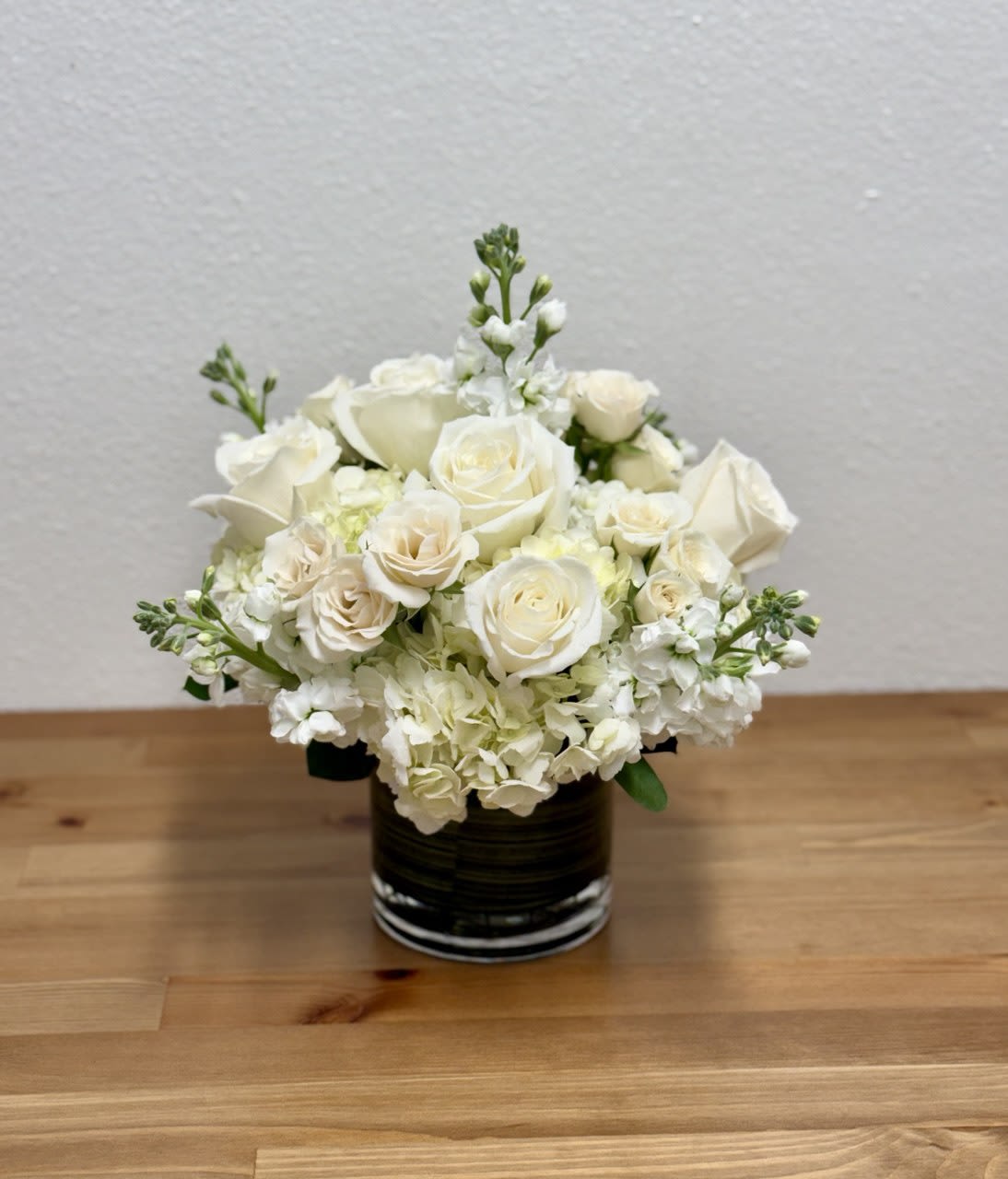 White rose bouquet in a dark glass vase