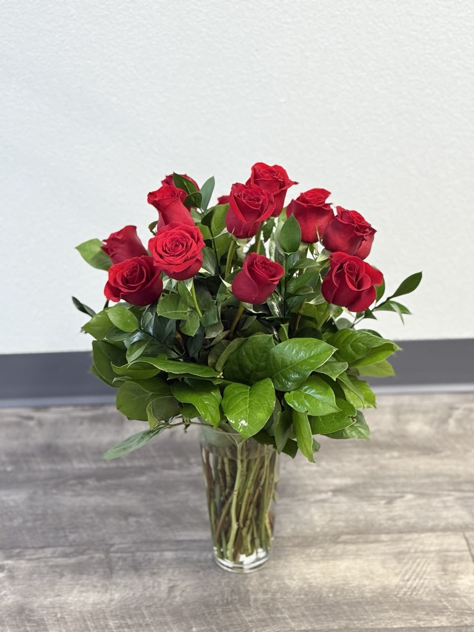 Red roses arranged in a clear glass vase