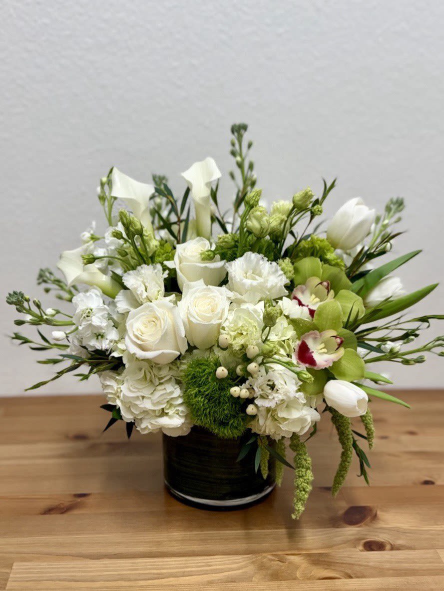 White and green floral arrangement in a black vase