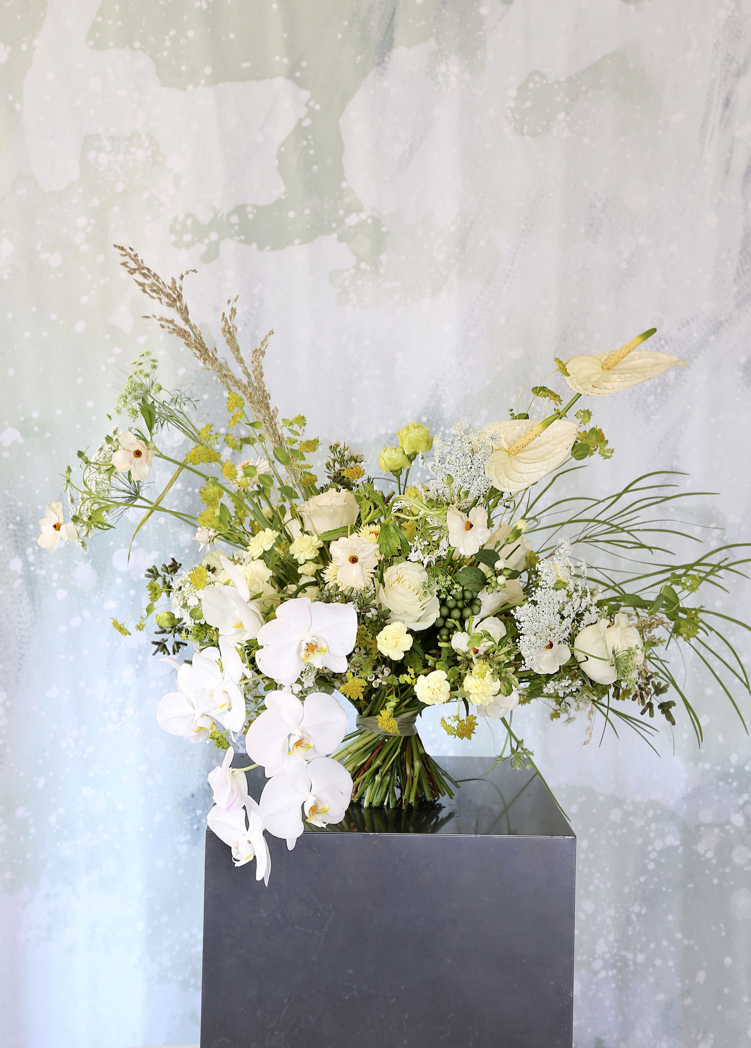 Pure - A Luxury elegant Cream Ivory yellow colorway  handtie bouquet created by Garden roses, Phalaenopsis Orchids, Anthurium, Lisianthus, Ranunculus, Hydrangeas and seasonal greenery and blooms. This handtie Bouquet wrap with ribbon and arrange in 8" round glass vase and gift box. Disclaimer: Photo just represent the overall style, look and feel, which may not be able to identically replicate in some instance. We will only substitute item of equal value or higher value. 