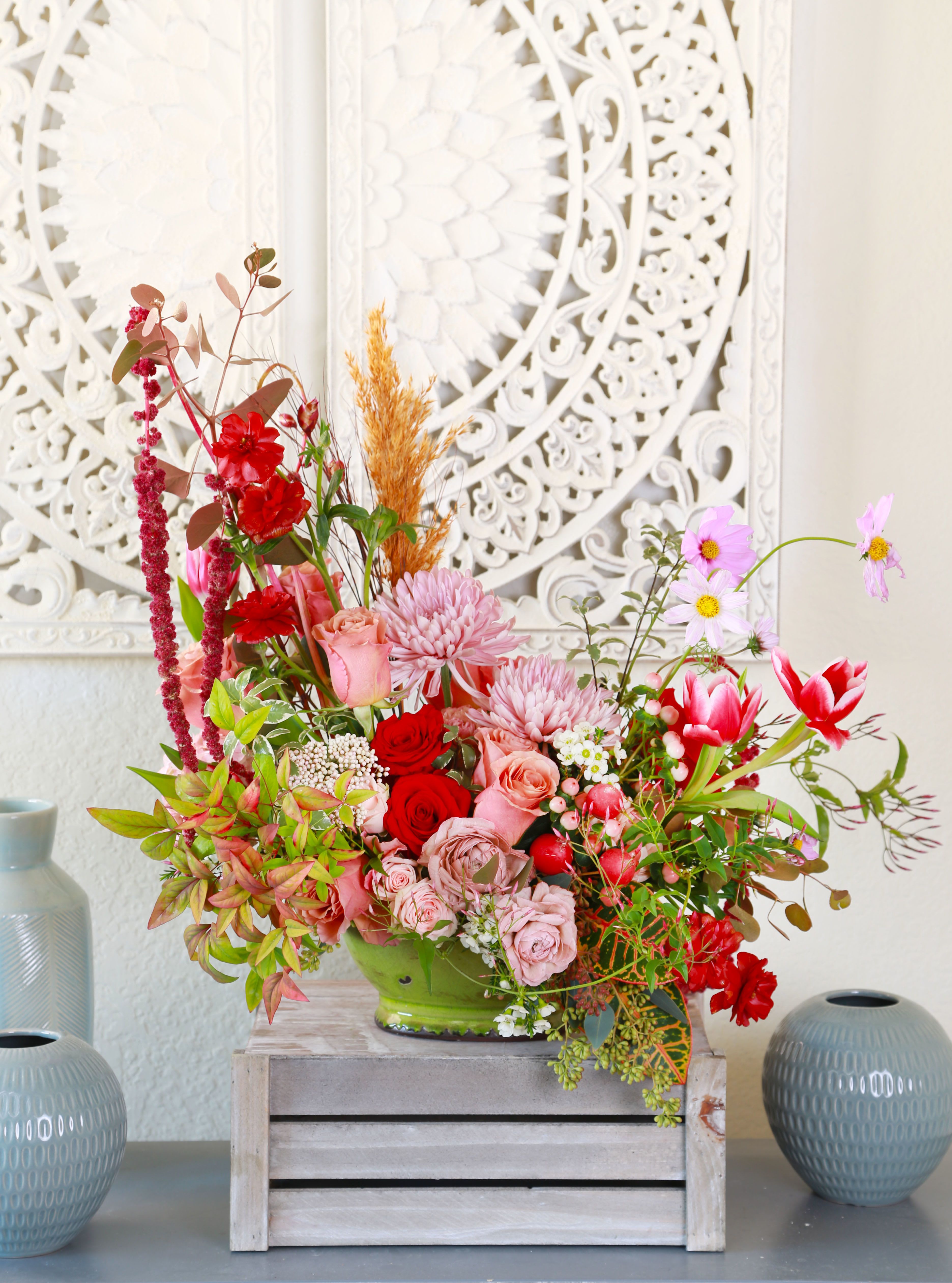 Ros'e Love Story - A romantic garden- style arrangement design to capture the beauty of love in every shade. Featuring Lush Red Garden roses and Moca Rose, Hydrangea, soft lavender Chrysanthemums, Tulips, Cosmo, Ranunculus, Amaranthus, Spray rose, Rice Flower, Berries, Radish and seasonal accent blooms. This arrangement is artfully layer with textured greenery and whimsical stems for a nature yet refine look. Design in a charming ceramic container, it brings warmth, passion, and elegance to any space. Perfect for Valentine's Day, anniversaries, or simply say " I love You" in the most beautiful way. Color palette: Red , Blush, Moca, soft Pink, Fresh Green. Arrangement size: Medium size 20"x 21" x10" The arrangement will be delivered with branded gift box as picture and greeting card