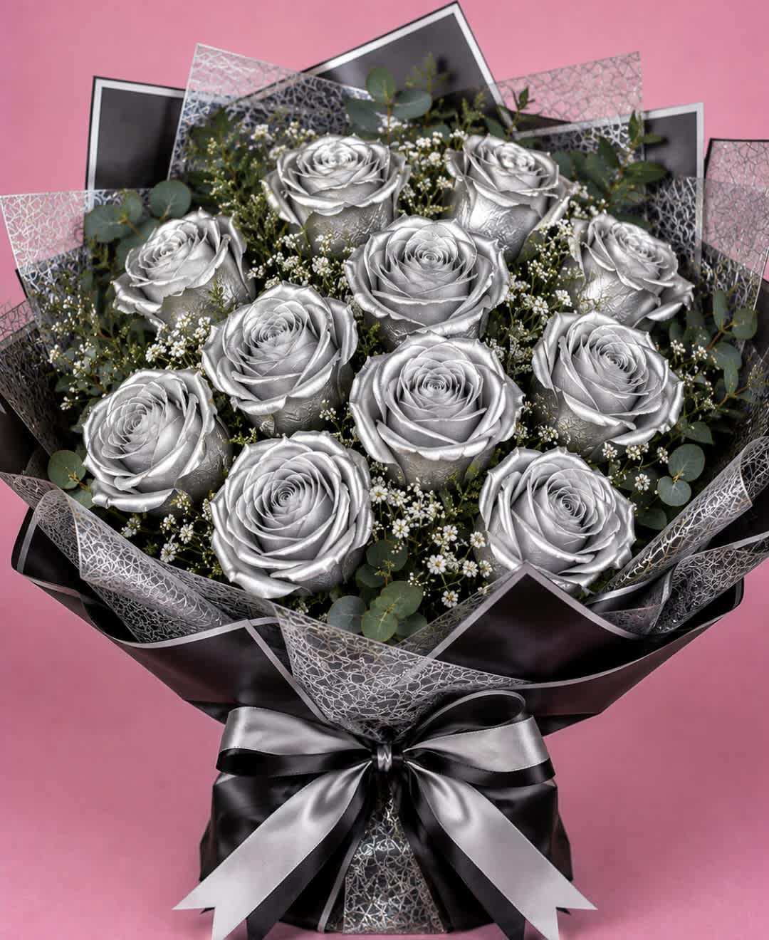 Bouquet of silver roses with baby's breath and eucalyptus, wrapped in black paper with a silver ribbon.