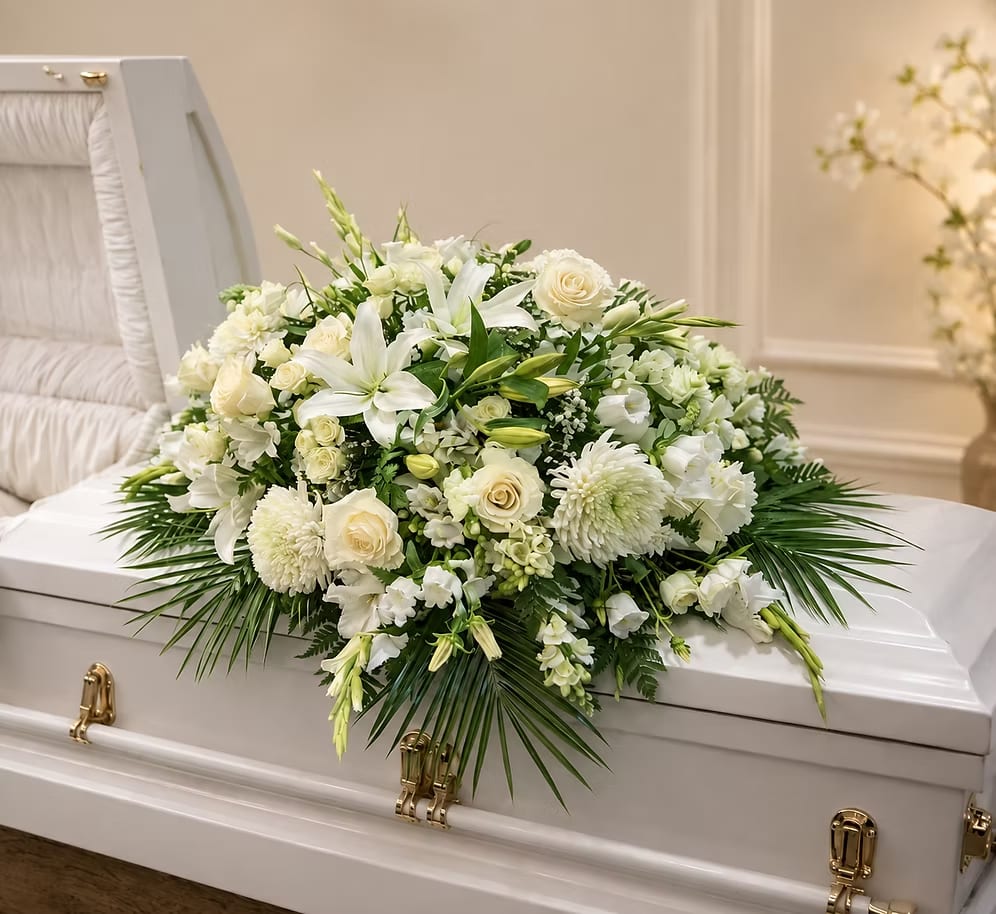 White floral spray on a white casket