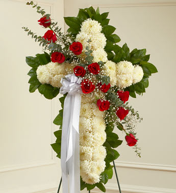 Cross-shaped floral spray with red roses and white chrysanthemums on a stand