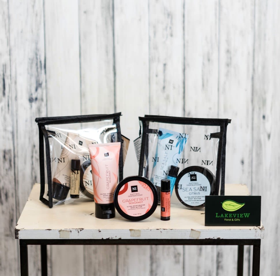 Two clear toiletry bags with assorted bath and body products on a table