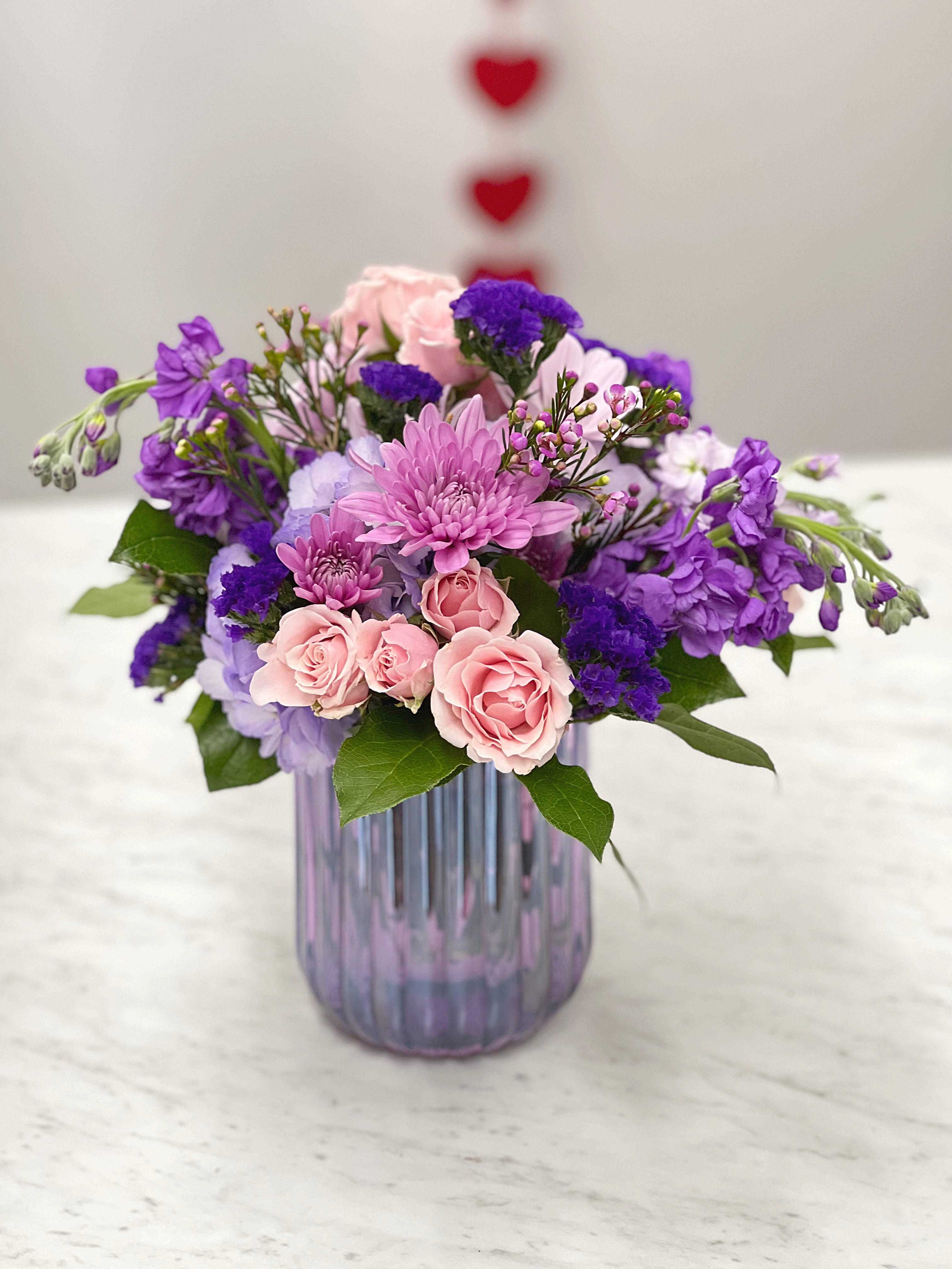 Pink and purple mixed bouquet in a ribbed glass vase