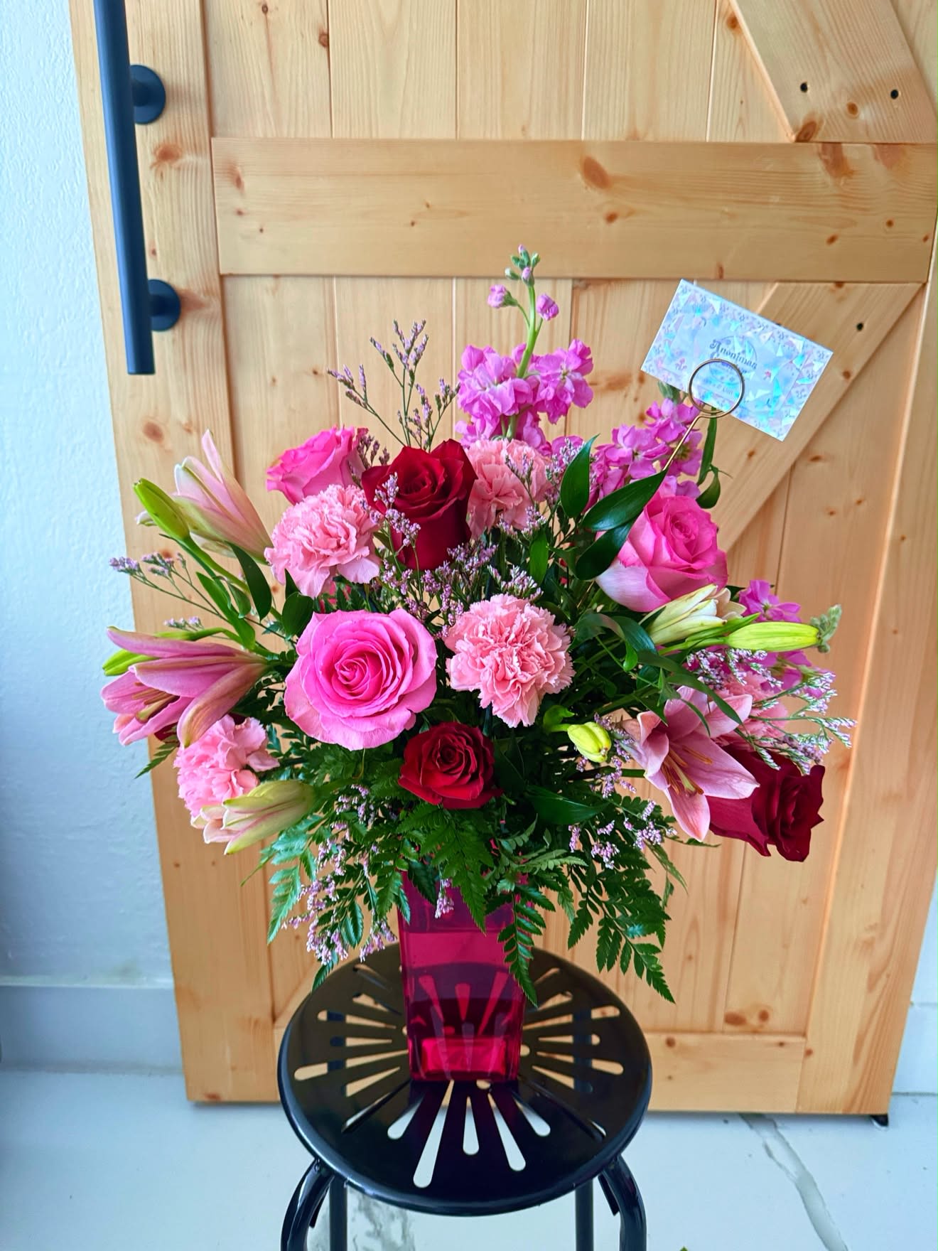 Blush &amp; Bloom Vase Arrangement - A graceful floral arrangement featuring premium roses, fragrant lilies, carnations, and seasonal blooms, accented with fresh greenery in a modern glass vase. Designed to brighten any celebration, this elegant arrangement is perfect for birthdays, anniversaries, congratulations, or simply to make someone smile.   Flower colors may be customized to your preference, subject to seasonal availability.