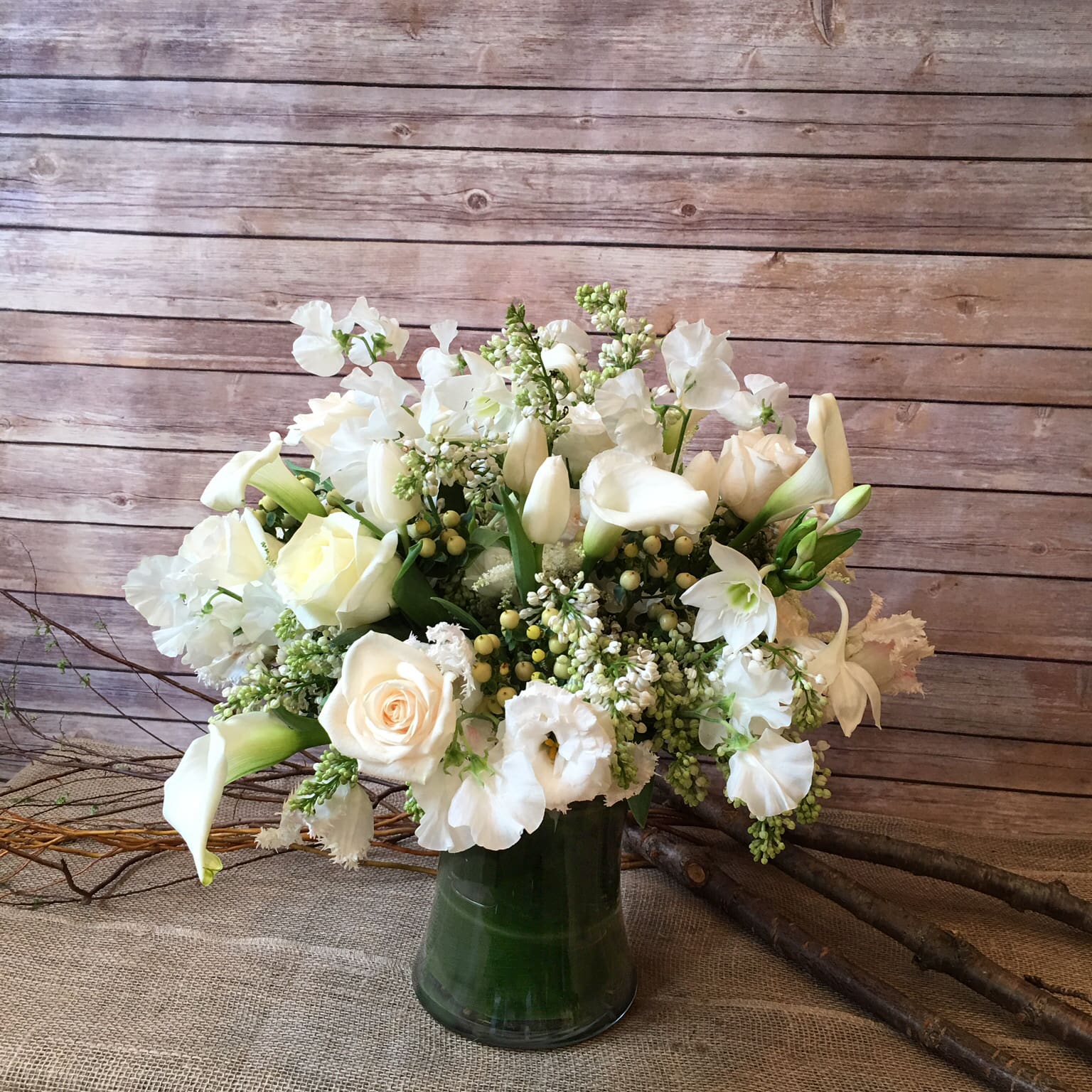 SNOW WHITE - LOVELY PURE WHITE ARRANGEMENT WITH WHITE SWEET PEAS, WHITE TULIPS, WHITE ROSES, WHITE LISIANTHUS, WHITE CALLA LILIES, WHITE LILAC, WHITE HYPERICUM, WHITE AMAZON LILIES, AND WHITE ASTILBE.