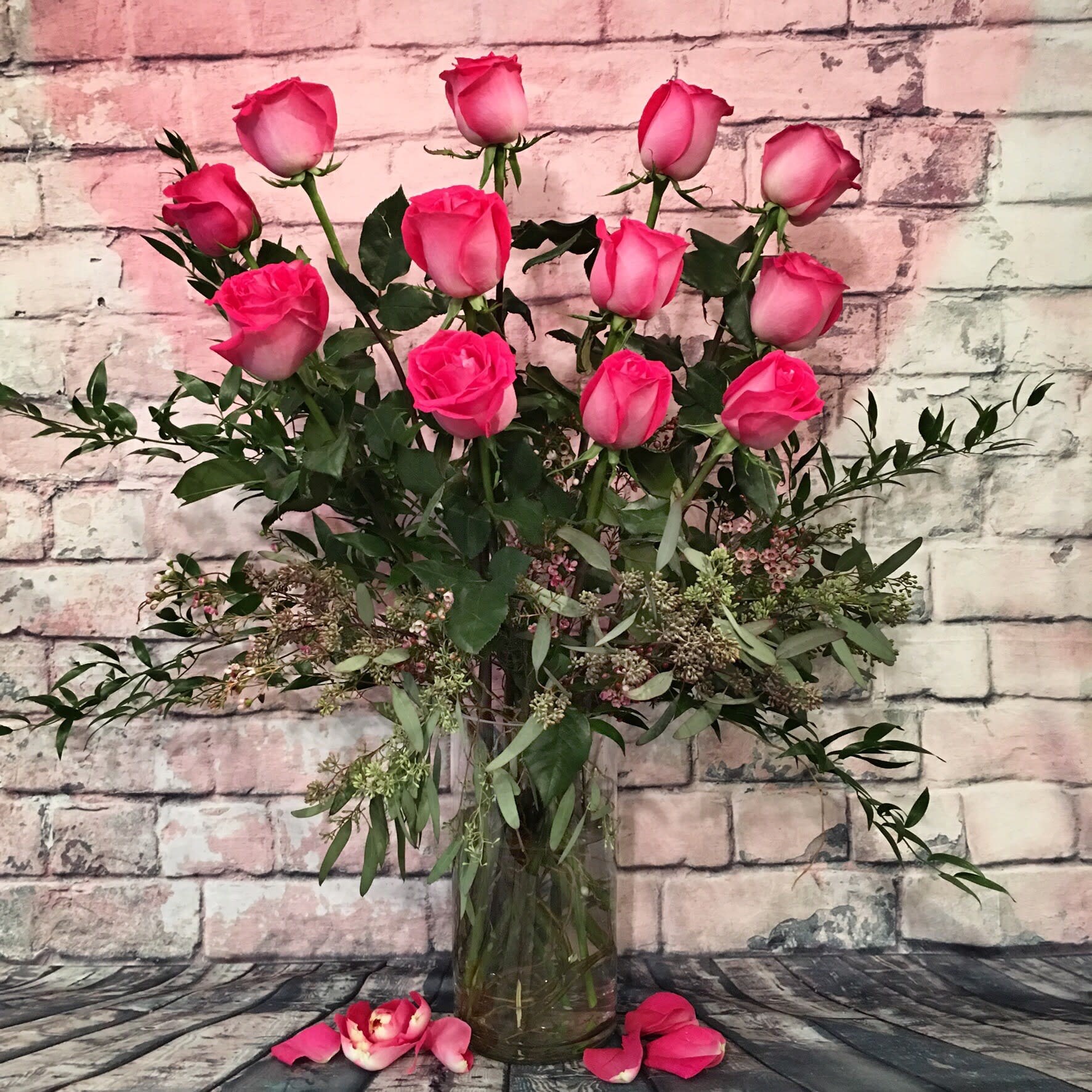 CE SOIR / HOT PINK COLOR ROSES - We are pleased to highlight our exquisite collection of long-stemmed roses, expertly arranged by Flowers by Philip. These classic arrangements, accented with seasonal foliage, are available in three stunning options:  * **Standard Version:** Dozen long-stemmed roses  * **Deluxe Version:** Dozen and a half long-stemmed roses  * **Premium Version:** Two dozen long-stemmed roses   For a truly unforgettable gift, choose the timeless elegance of long-stemmed roses by Flowers by Philip.