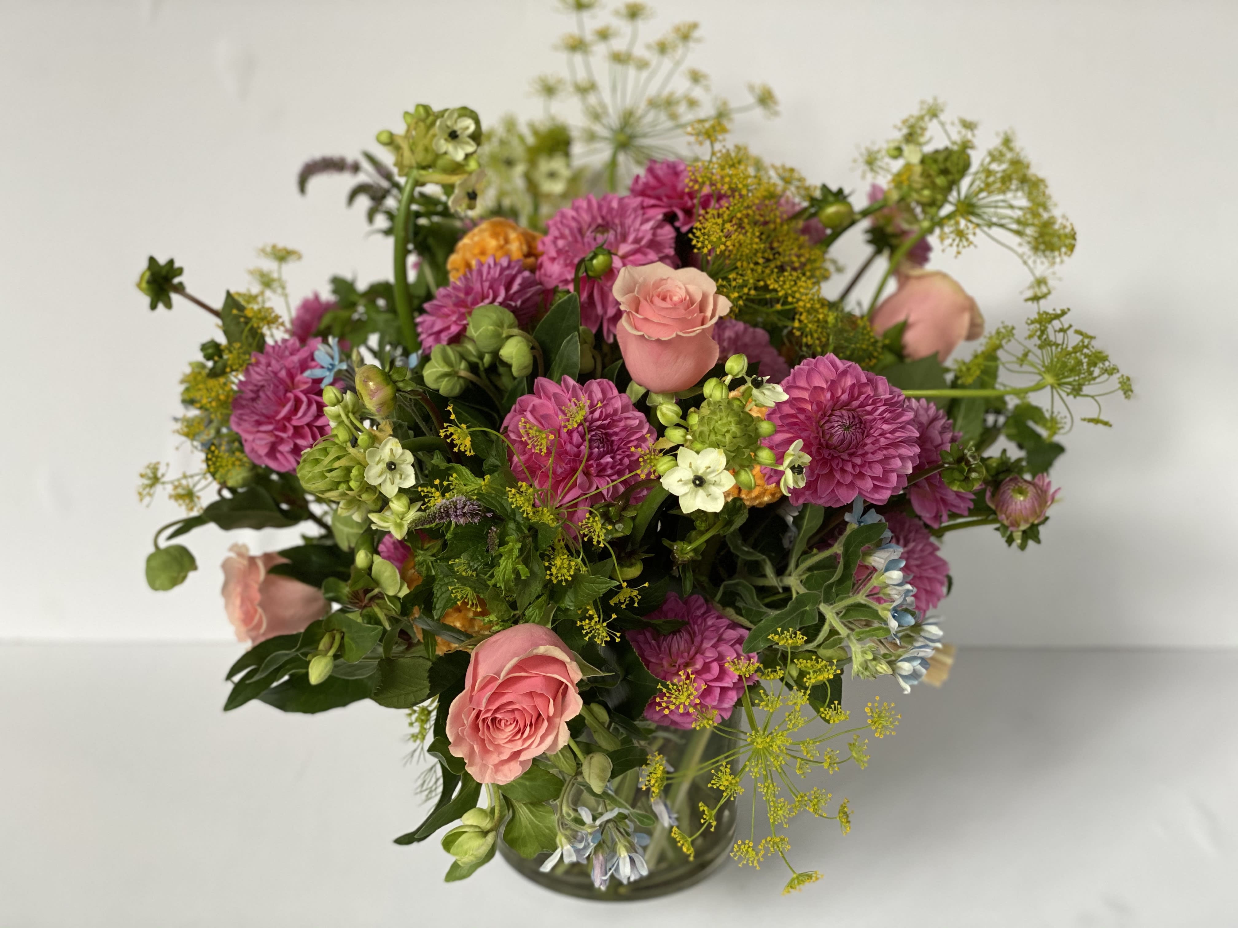 Dutch Explosion  - This lush composition is surrounded of  arabicum, dahlias, light pink roses , oxypetalum light blue, mentha jocka in a low glass cylinder.